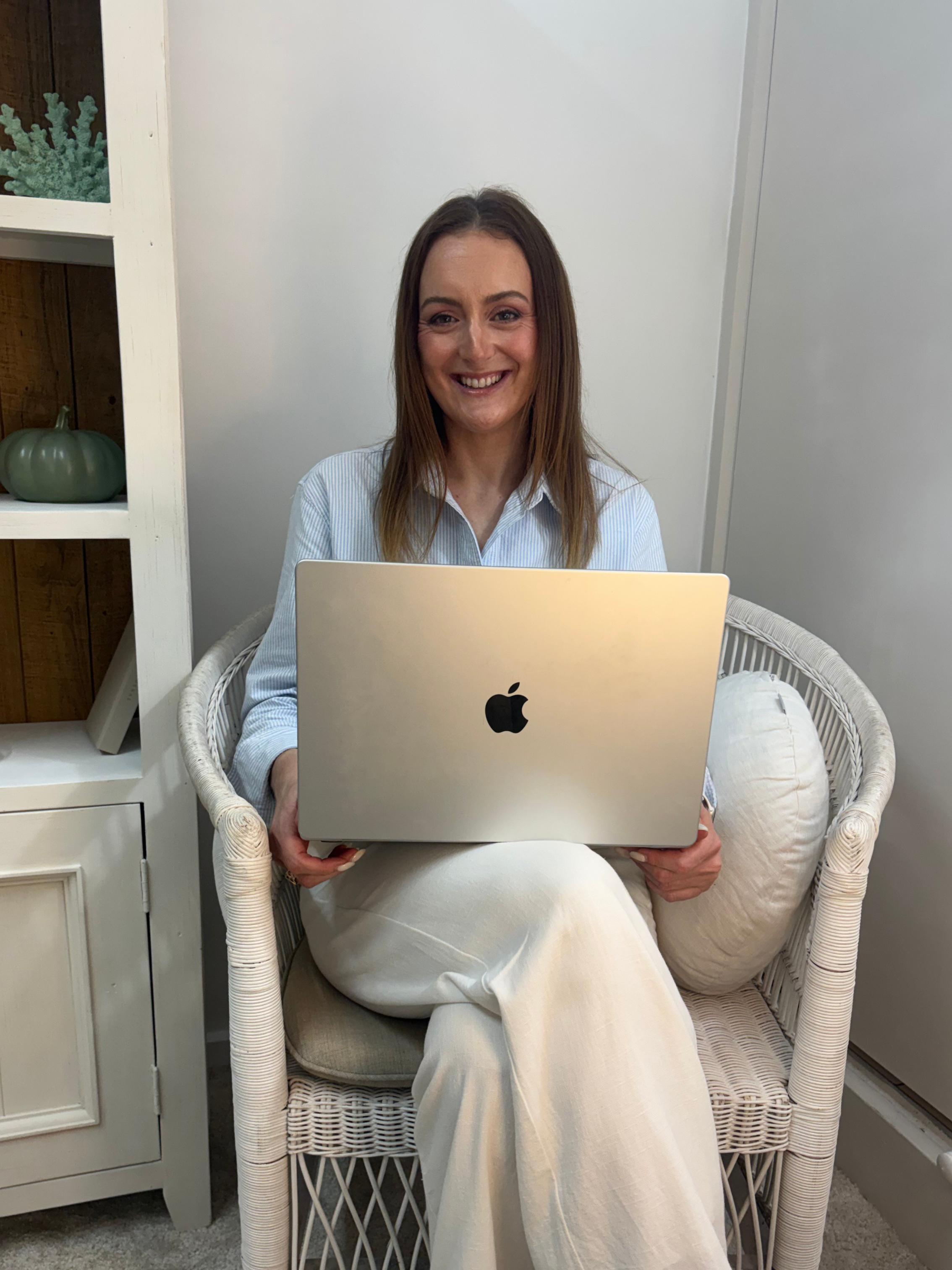 Jazmin Pursell, sitting with laptop, smiling