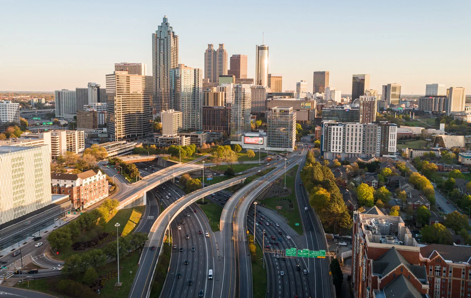 Aerial view of a city skyline with high-rise buildings and highways, showing traffic during daytime.