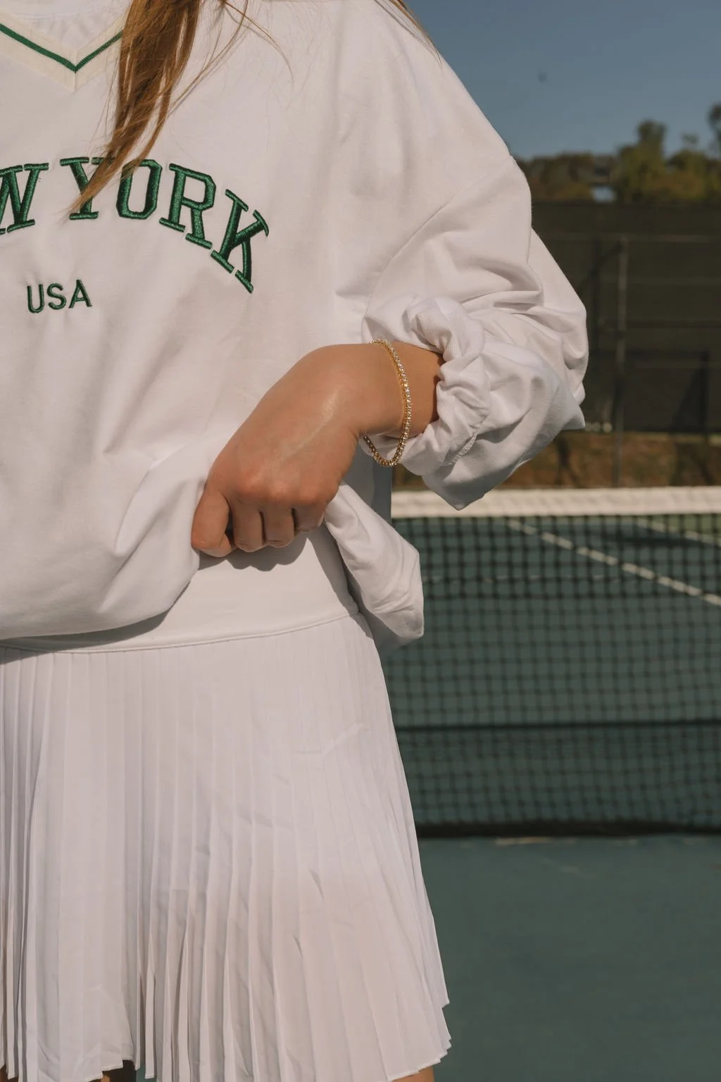 Country club girl with tennis skirt and vintage sweatshirt editorial