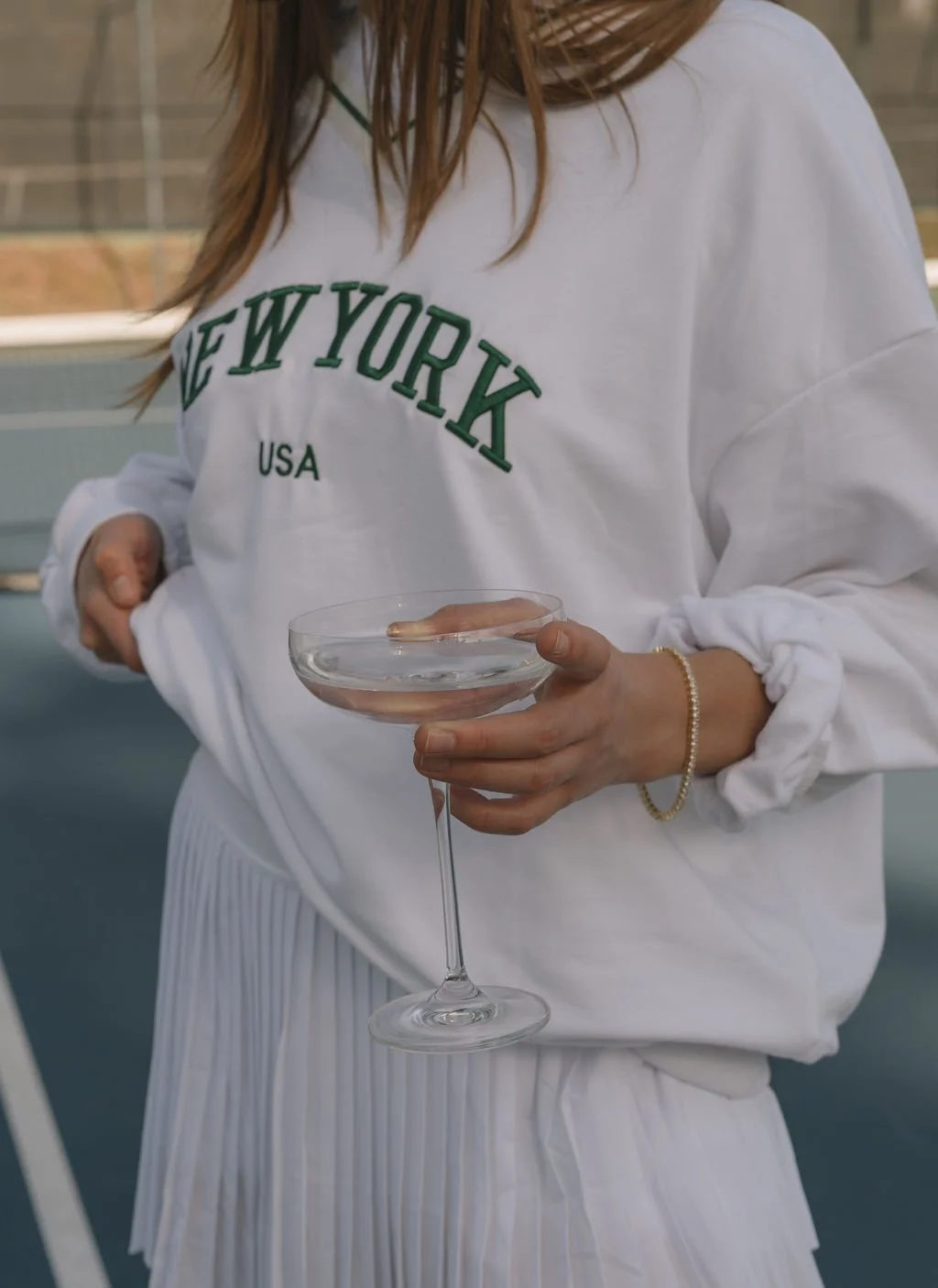 Posh girl on tennis pickleball court with champagne