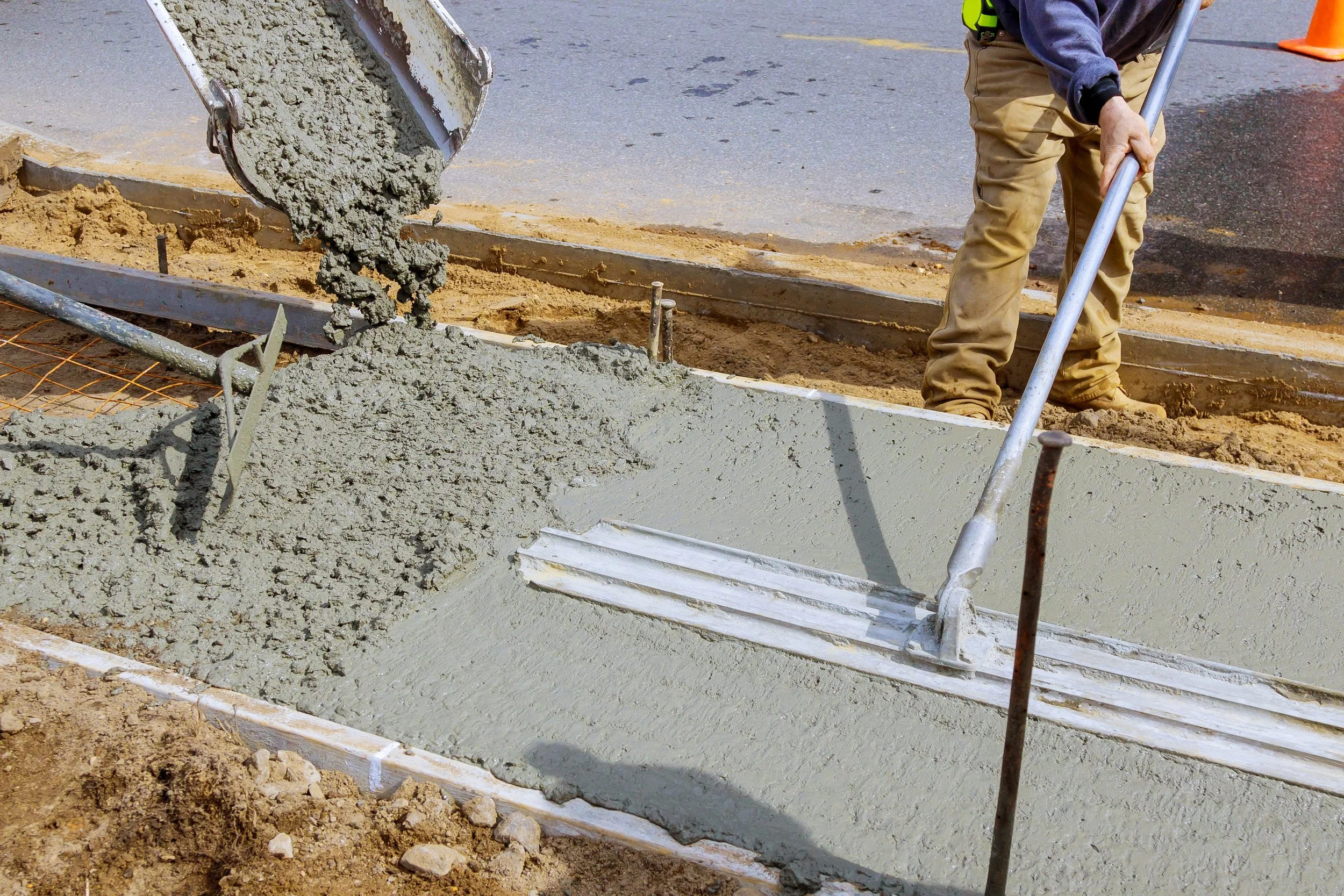construction-worker-pour-cement-for-sidewalk-in-co-2023-11-27-04-58-19-utc.jpg