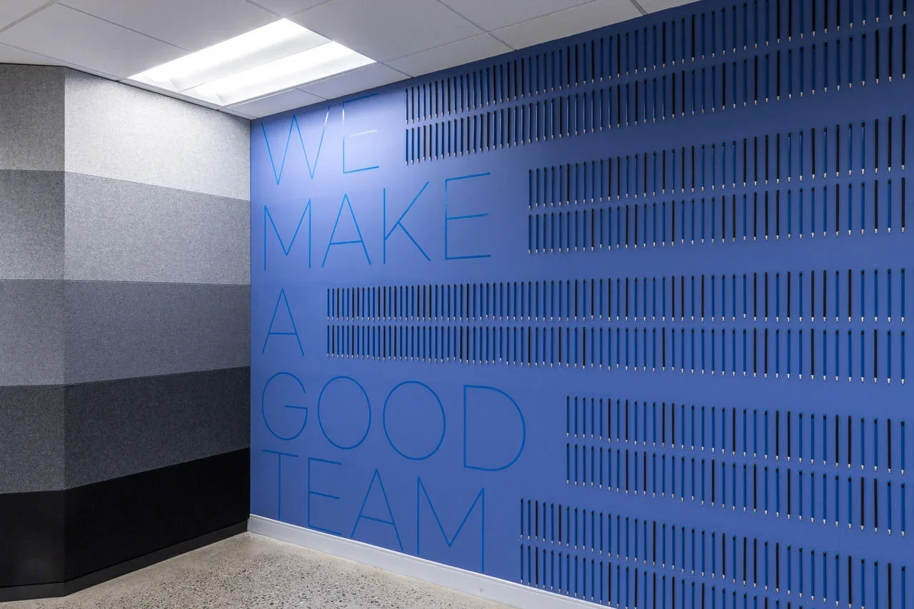 Interior wall with blue panels and the words 'We make a good team' written on it for motivational decor.