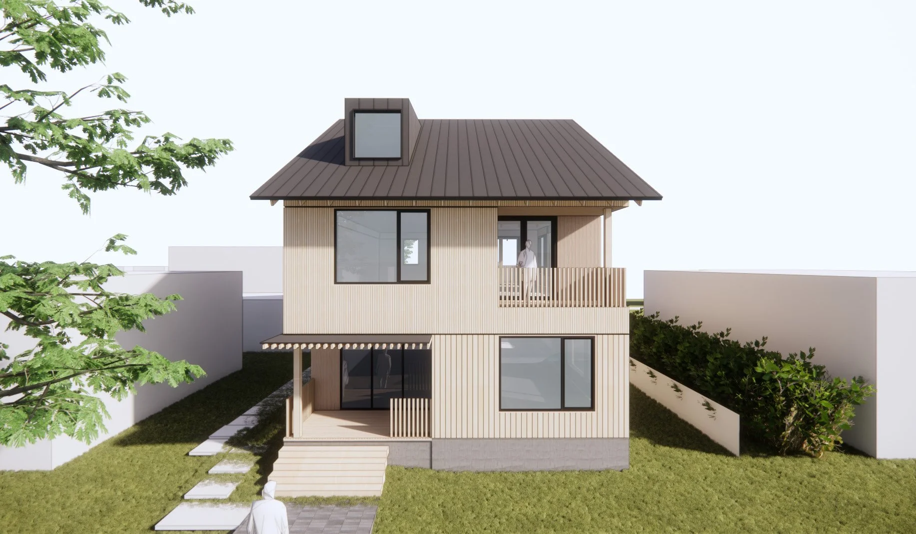 A modern two-story house with light wood siding and a dark metal roof, featuring large windows, a small front porch, and a balcony on the second floor with a person standing on it. There are trees and bushes surrounding the house.