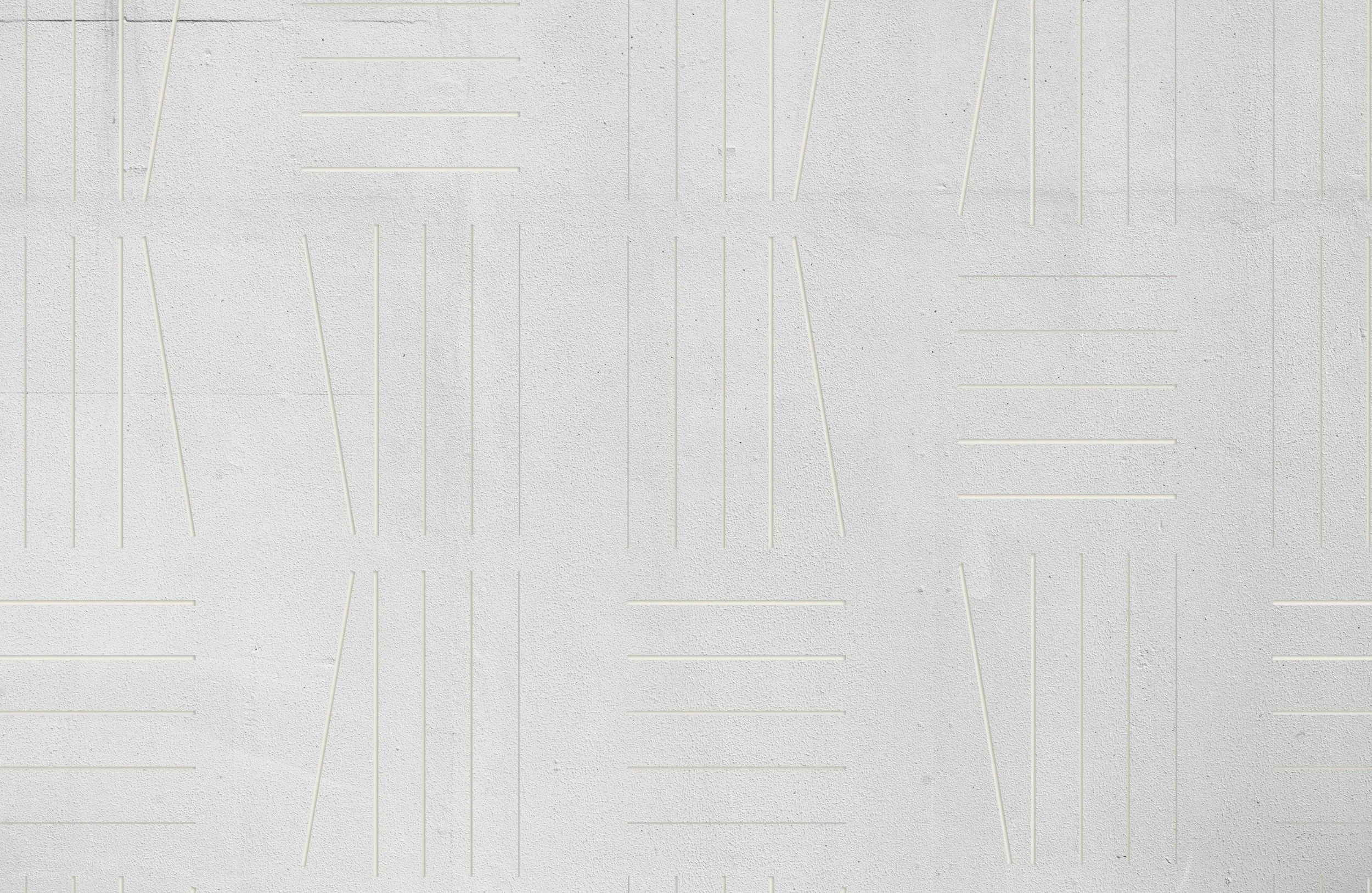 White textured wall with thin, elongated, raised and recessed linear patterns arranged in a random geometric pattern.