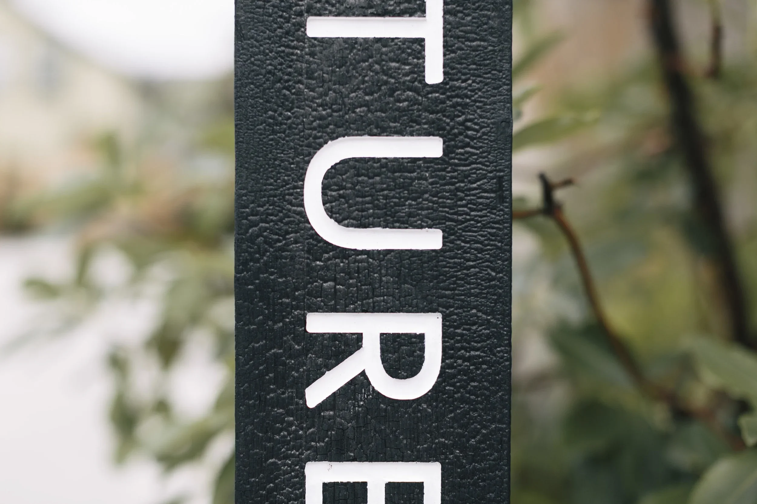 Close-up of a black textured pole with white letters spelling 'FERRY'.