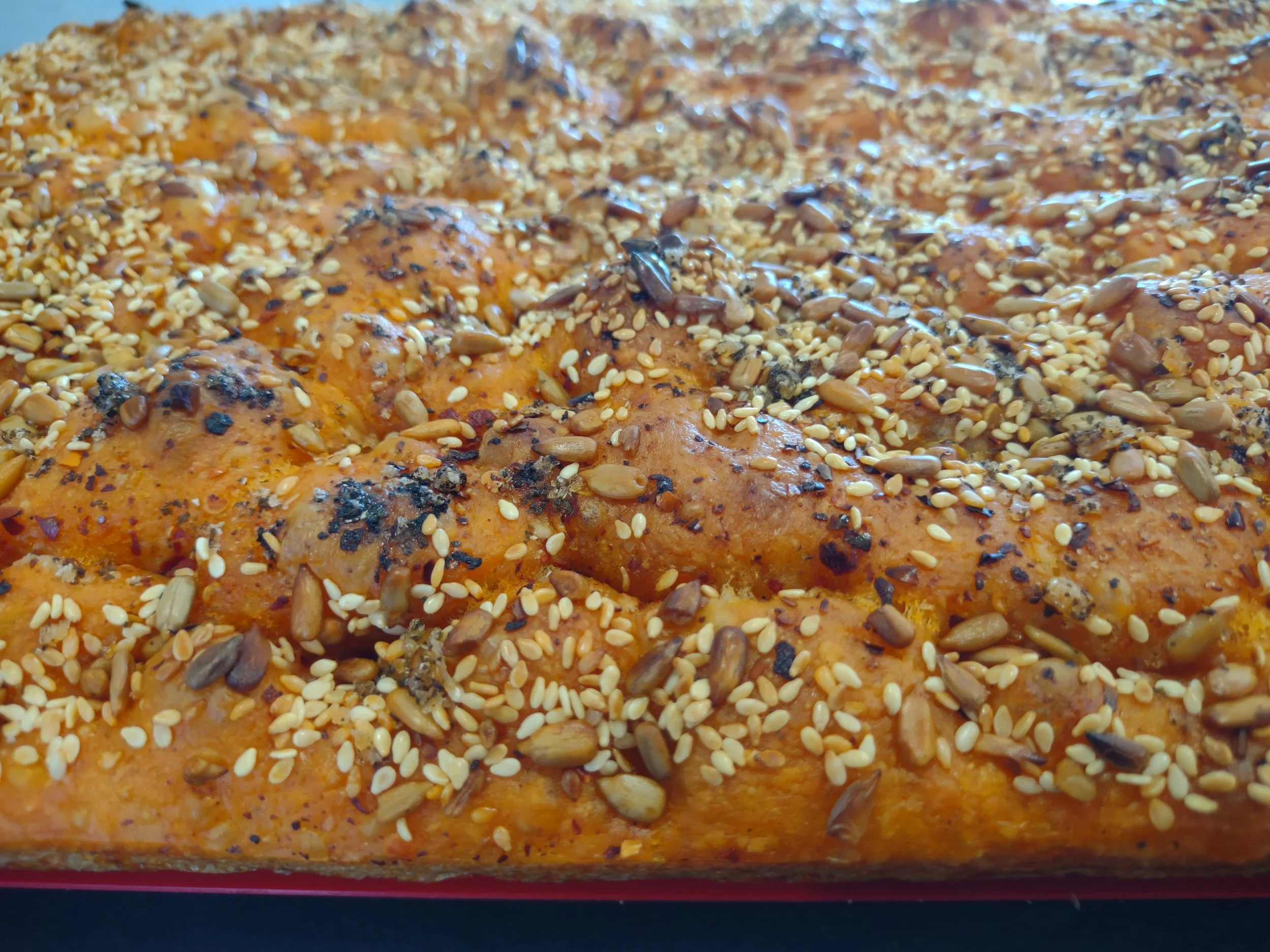 Spicy fresh-baked foccacia bread by Kapiti Delicious Doughs, topped with chilli oil, sunflower seeds, sesame seeds perfect for entertaining, delivered across the Kapiti Coast
