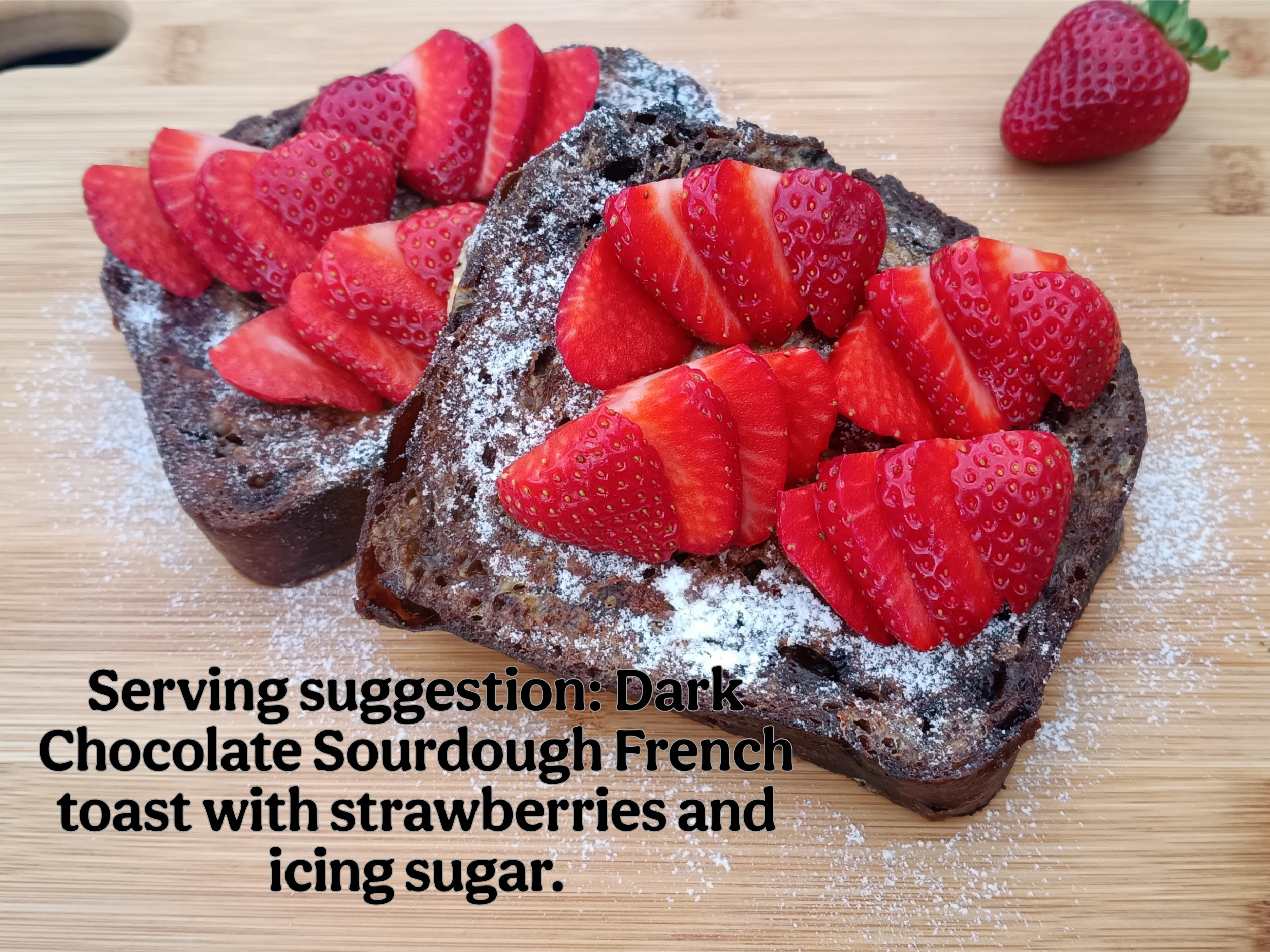 Chocolate Sourdough French toast with sliced strawberries and icing sugar sprinkle, serving suggestion for eating chocolate sourdough bread.