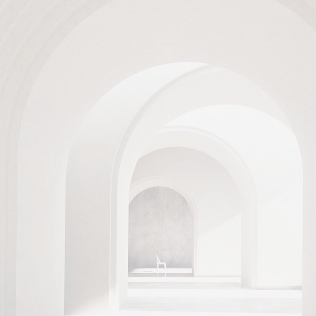 Series of white arches creating a tunnel-like perspective with a solitary chair at the far end.