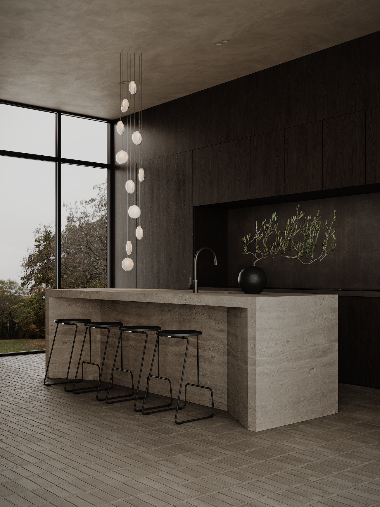 Modern kitchen with a large concrete island, black stools, a dark wood wall, and a black vase with greenery, next to a large window showing trees outside.