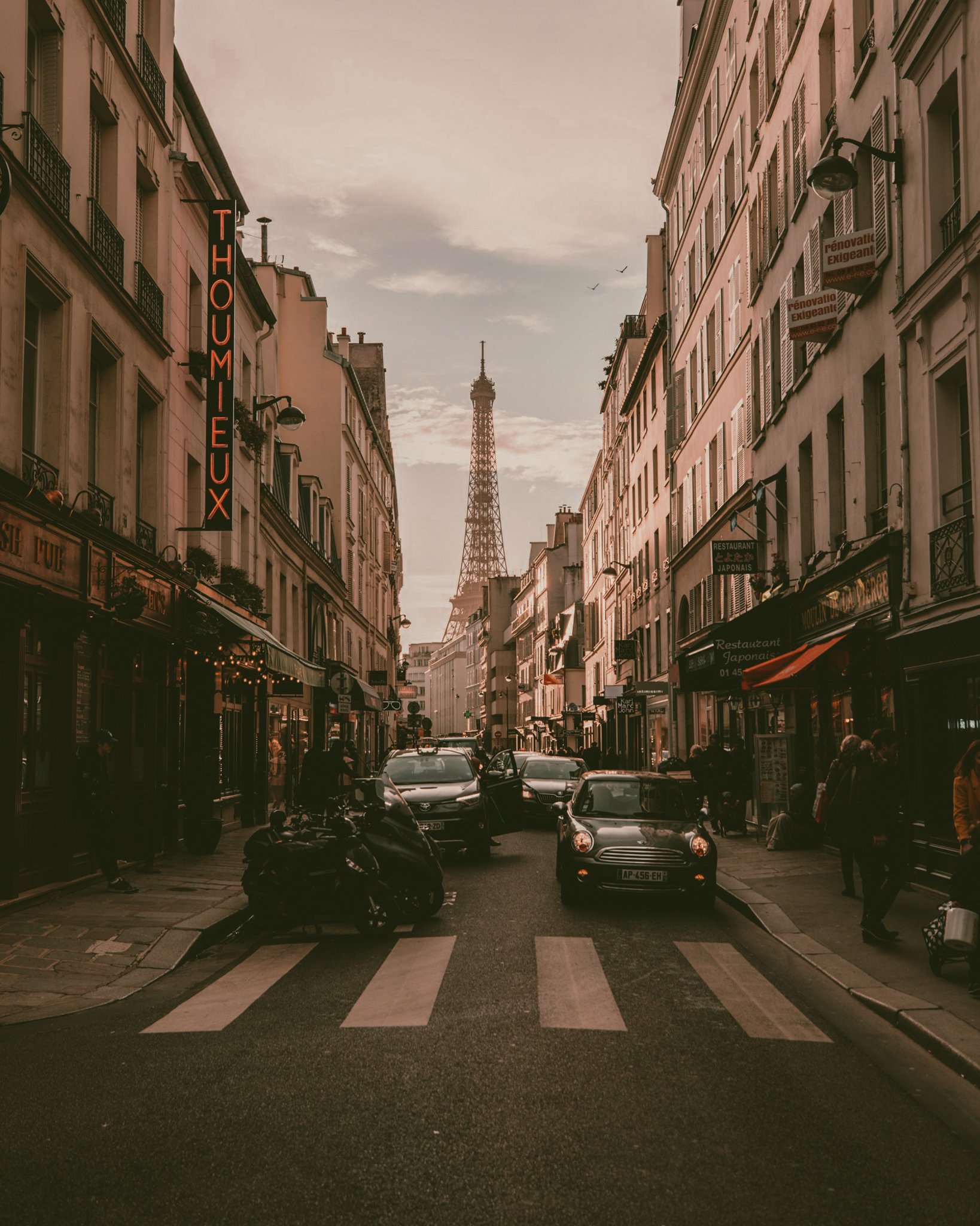 Eiffel Tower rising above a Paris street scene showcasing historic architecture and city life
