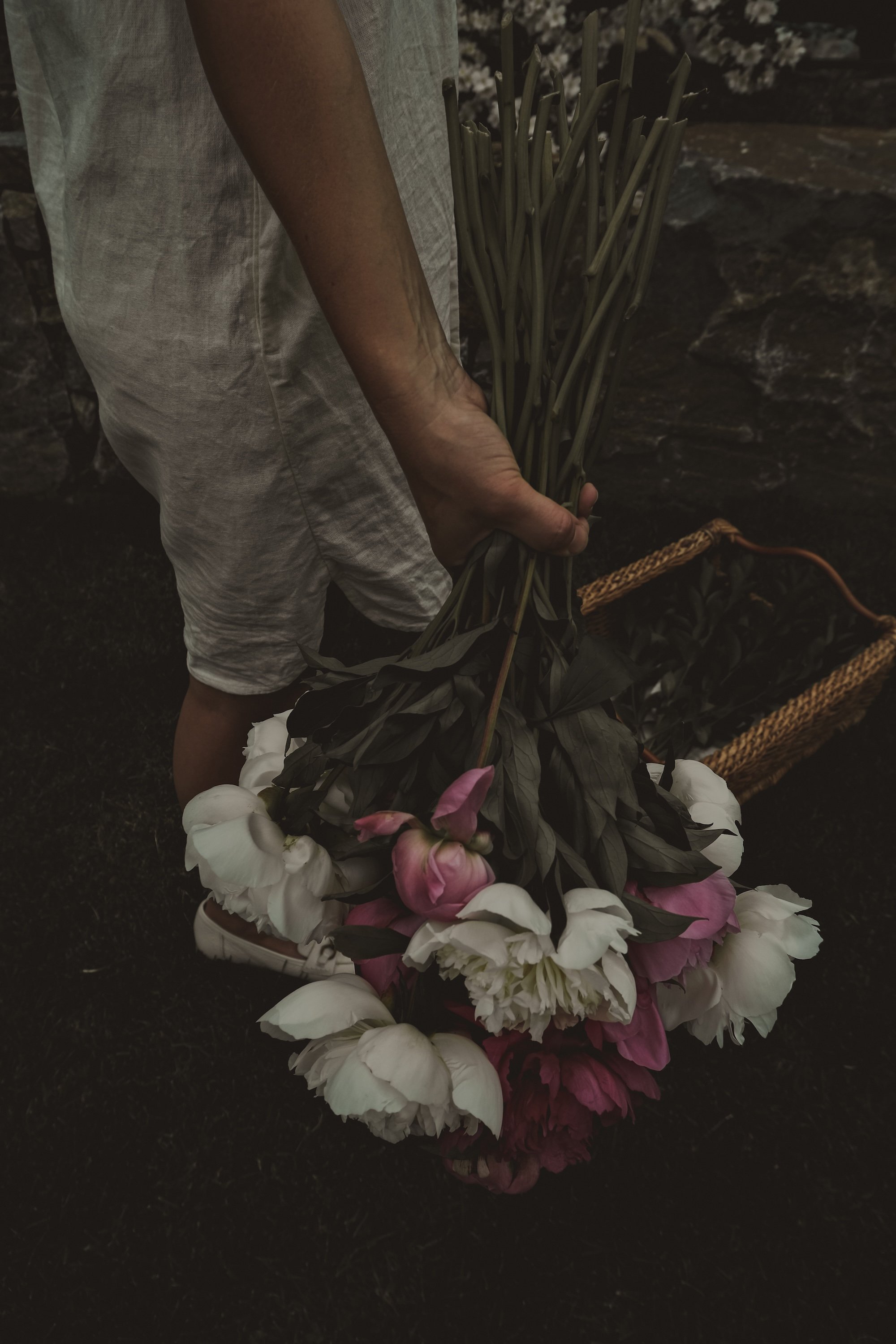 Person holding a large bouquet of pink and white flowers.