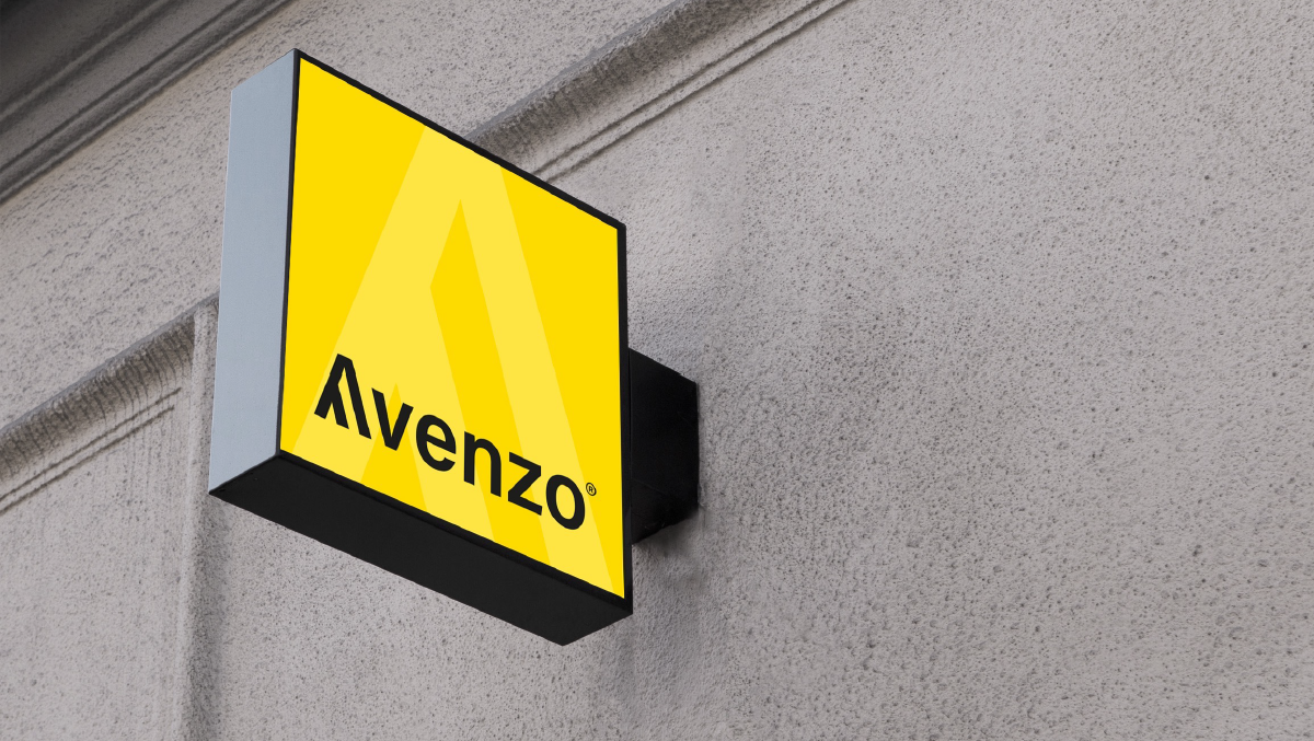 Sign with yellow background and black text that reads "Alvenzo" mounted on a gray wall outside a building.