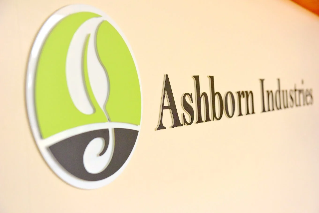 Logo of Ashbourn Industries featuring a stylized plant leaf and swirl design with the company name.