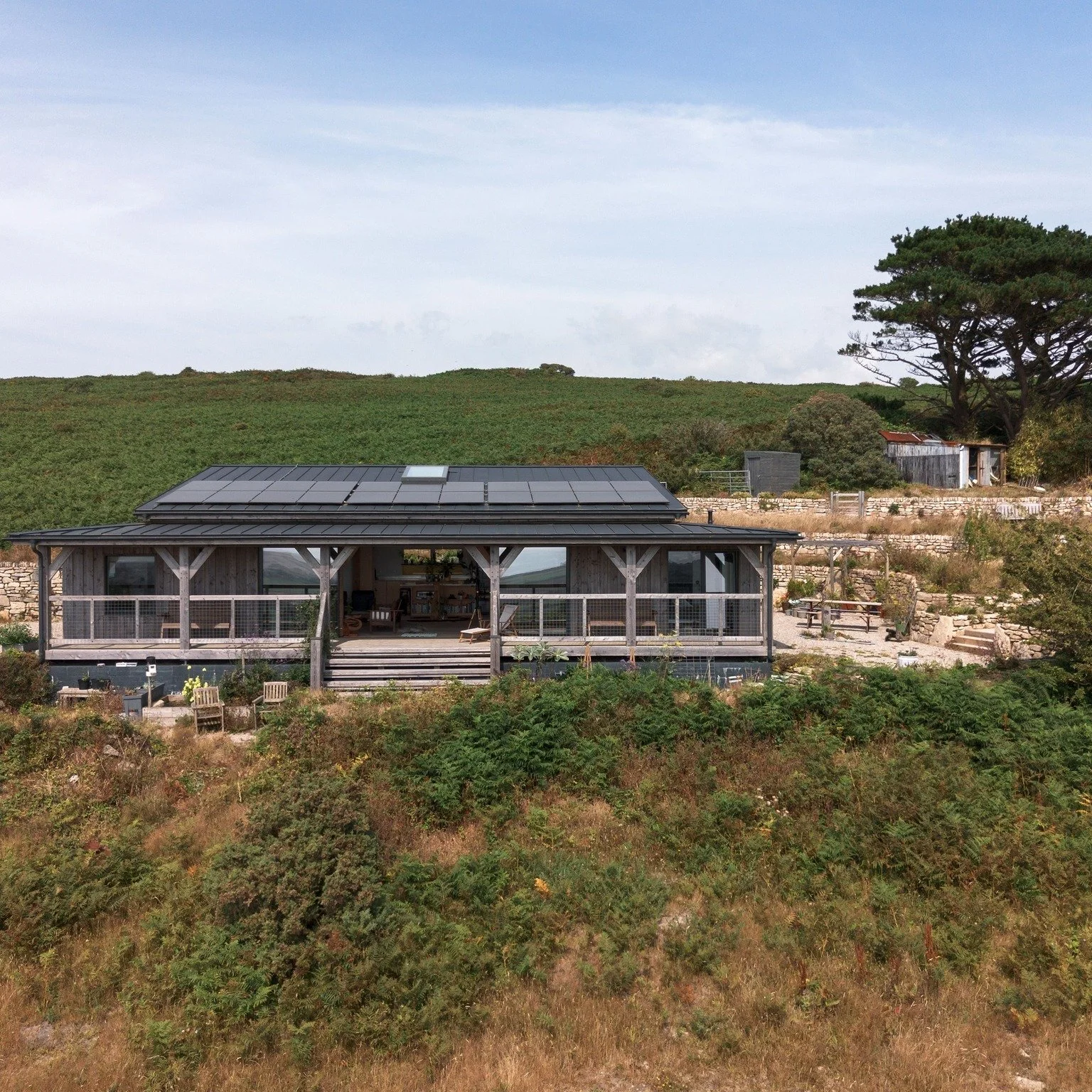 Another New Case Study - Skyfold House

Set within a gently sloping landscape with sweeping countryside and distant sea views, this single-storey three-bedroom home is designed to sit quietly within its surroundings while making the most of its excep
