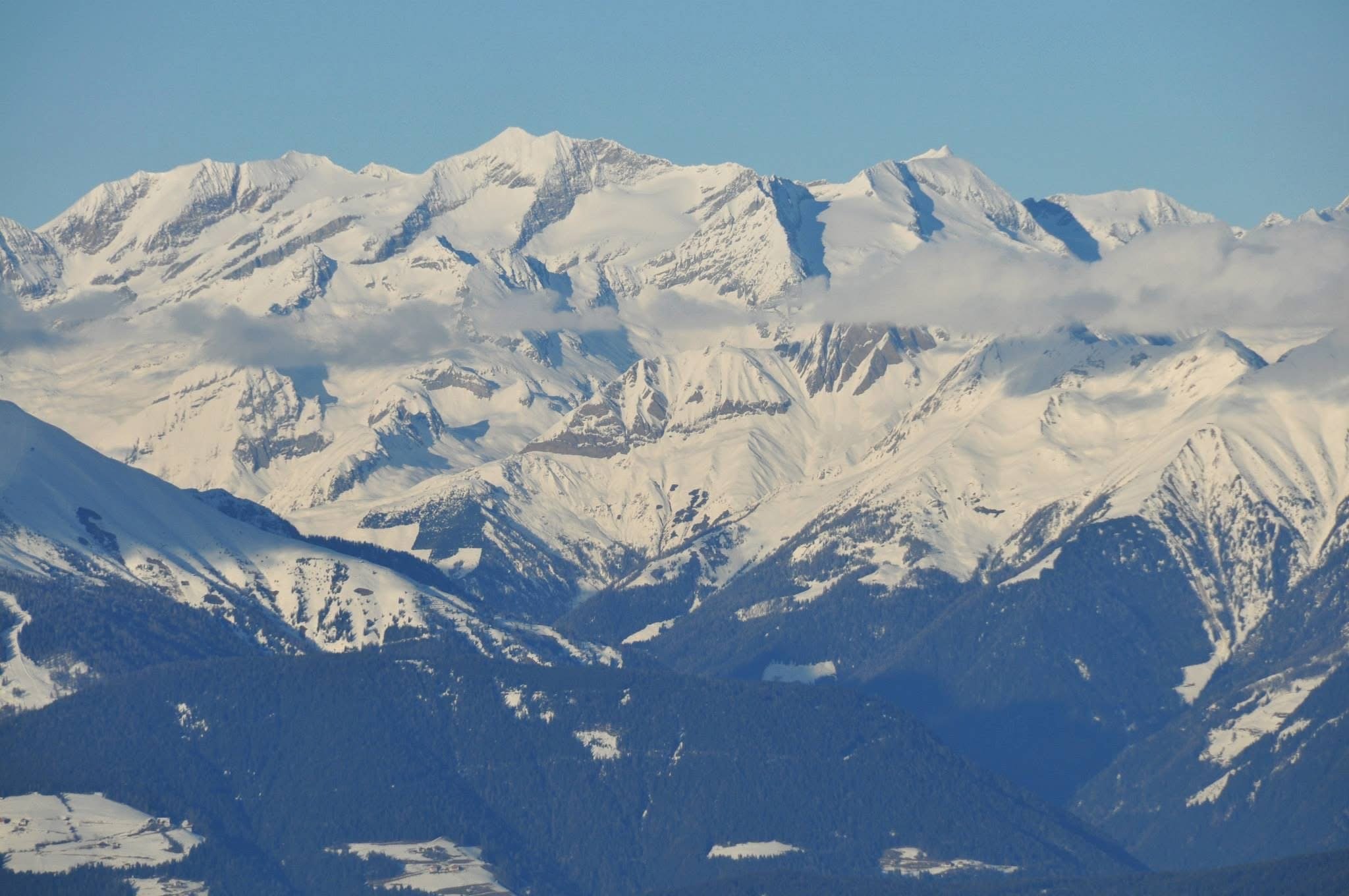 Snow-covered alpine mountain range in the Dolomites viewed from a distance on a clear winter day