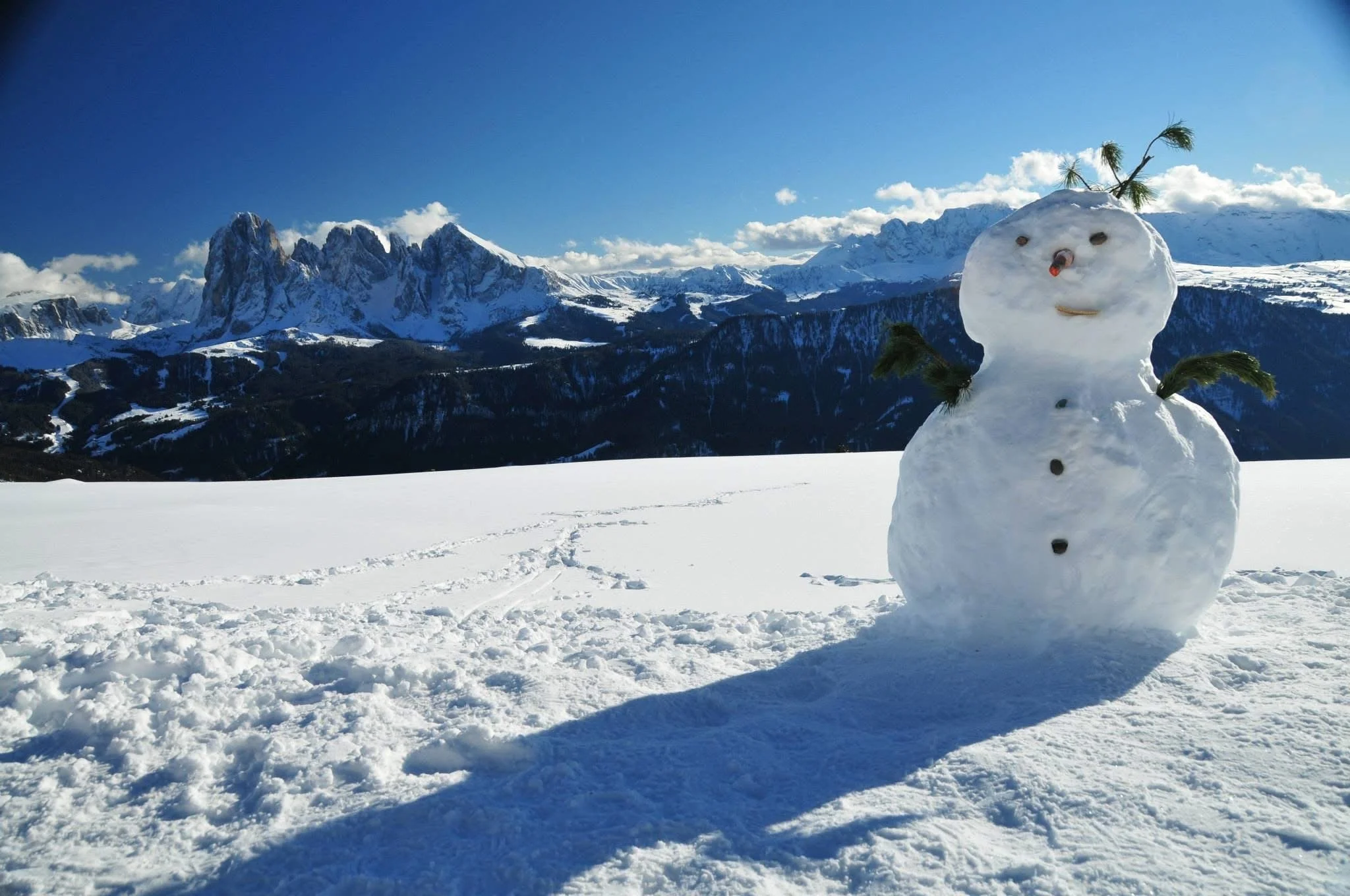 Snowman in a snowy Dolomites landscape with dramatic mountain peaks, representing winter activities without skiing or hiking