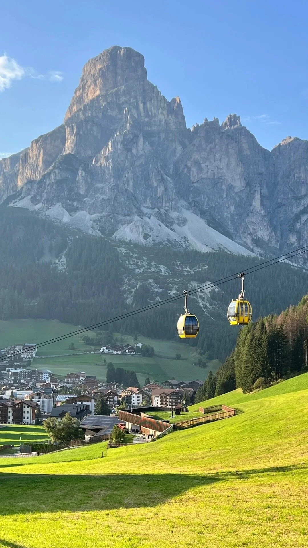 sassongher mountain in corvara with the town and cable cars