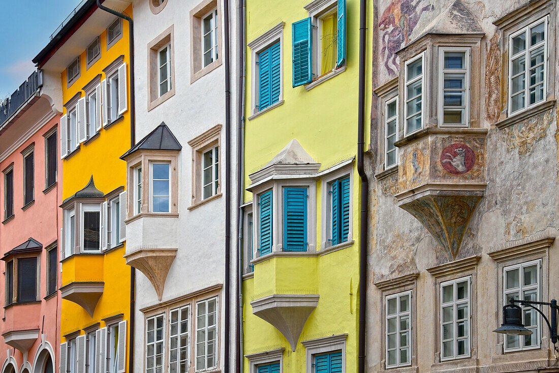 Colorful buildings in Bolzano old town with historic arcades and mountain backdrop in South Tyrol
