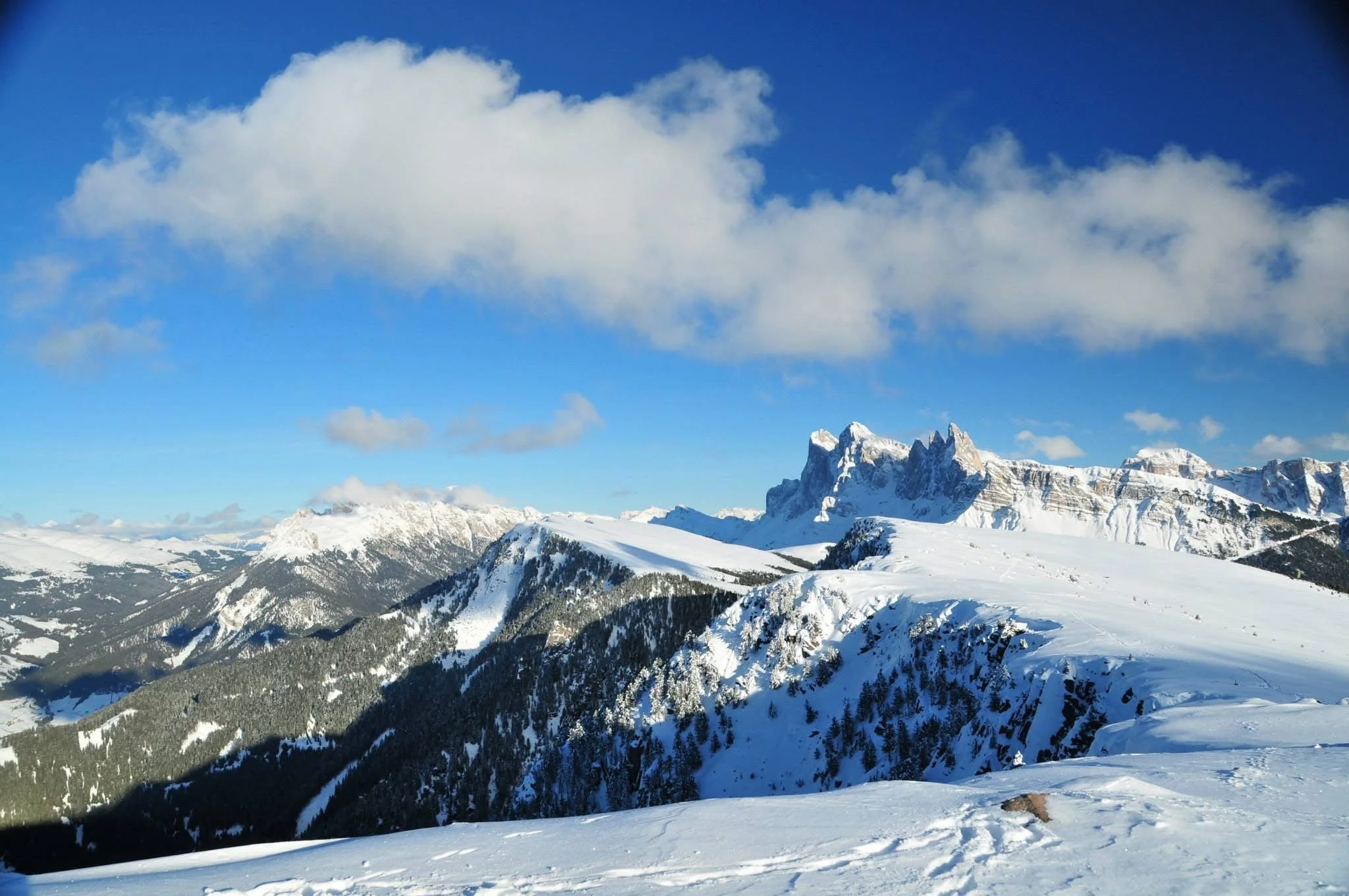 Snow-covered alpine mountain range in the Dolomites viewed from a distance on a clear winter day