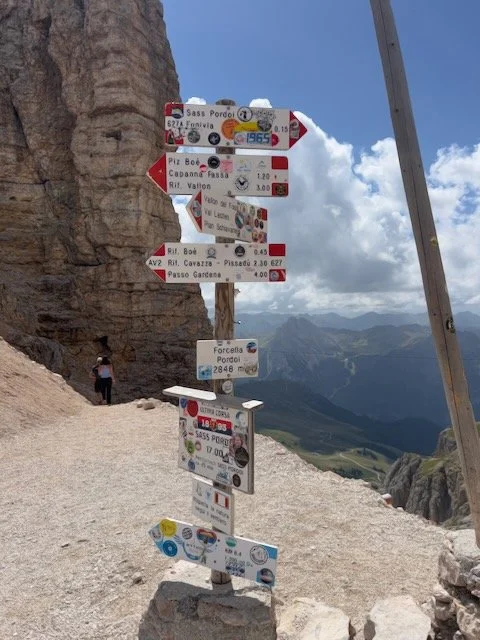 trail sign dolomites and mountains in background