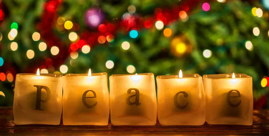 Christmas candles on the mantle spells out "P E A C E"