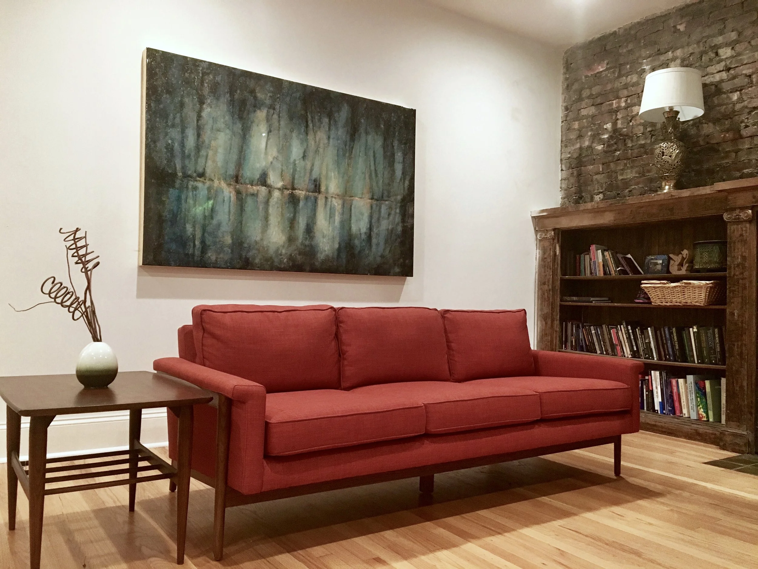 Commissioned Abstract Oil Painting from St. Claire Art Over a Red Couch in a Sitting Room