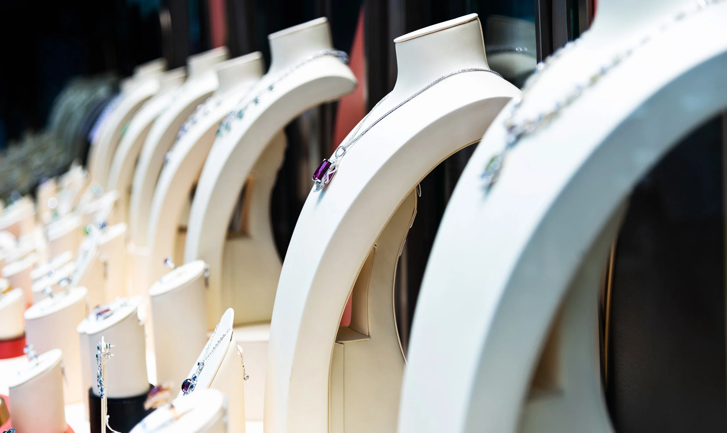 Schmuckständer mit verschiedenen Halsketten und Armbändern, hauptsächlich aus Silber, auf einem Ausstellungsdisplay in einem Geschäft.
