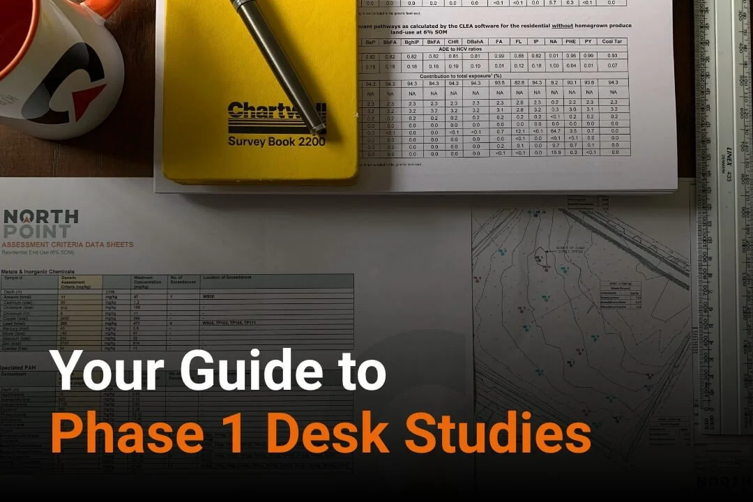 Overhead photo of maps, data sheets and a yellow survey notebook - blog cover for a Phase 1 desk study report.