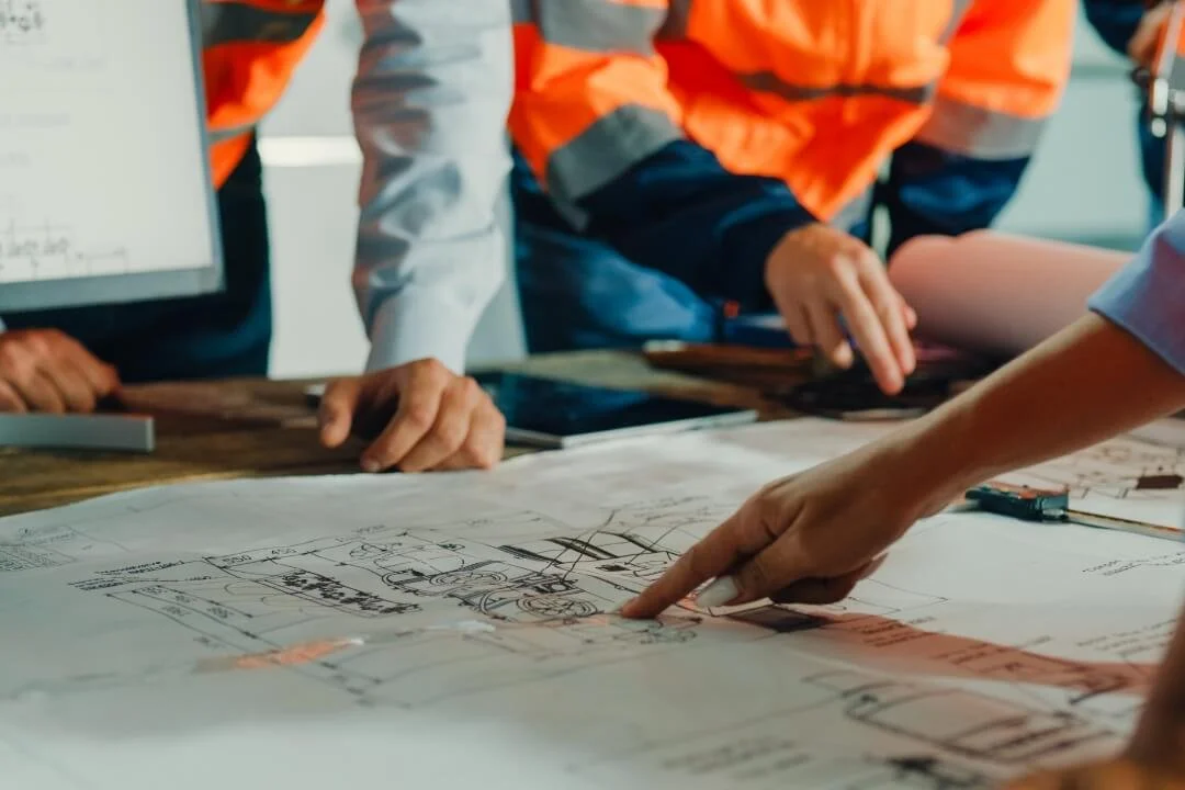 Engineers reviewing site plans and constraints during desk-based screening for a Phase 1 Desk Study (Preliminary Risk Assessment).
