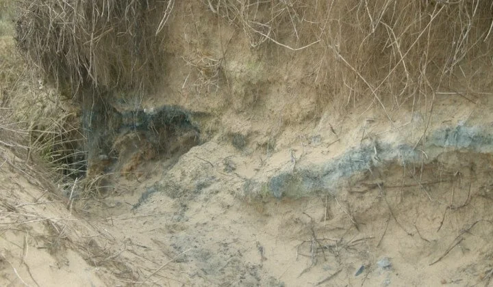 Close-up of contaminated soil layers exposed during geoenvironmental investigation for land remediation planning