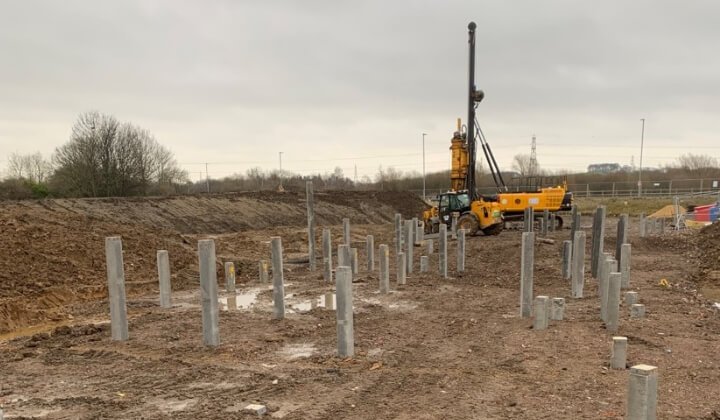 Geotechnical piling rig installing concrete piles on development site for foundation design.