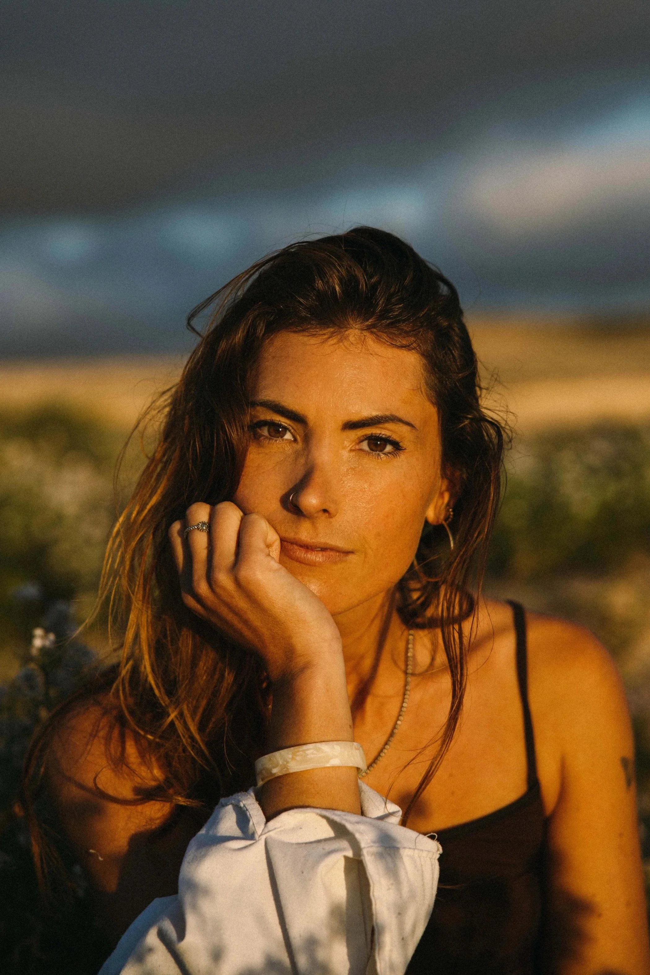 Portrait von Lisa Münzberger bei Sonnenuntergang mit dunklen Wolken am Himmel.