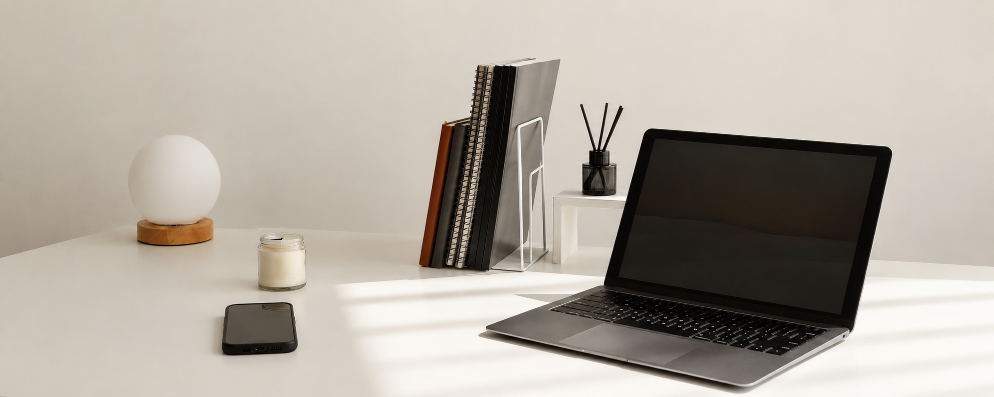 Bild eines Laptops und Notizbücher und eines Handys auf einem Schreibtisch. Alles ist vorbereitet für den Fotografie Workshop von Hanna Ki