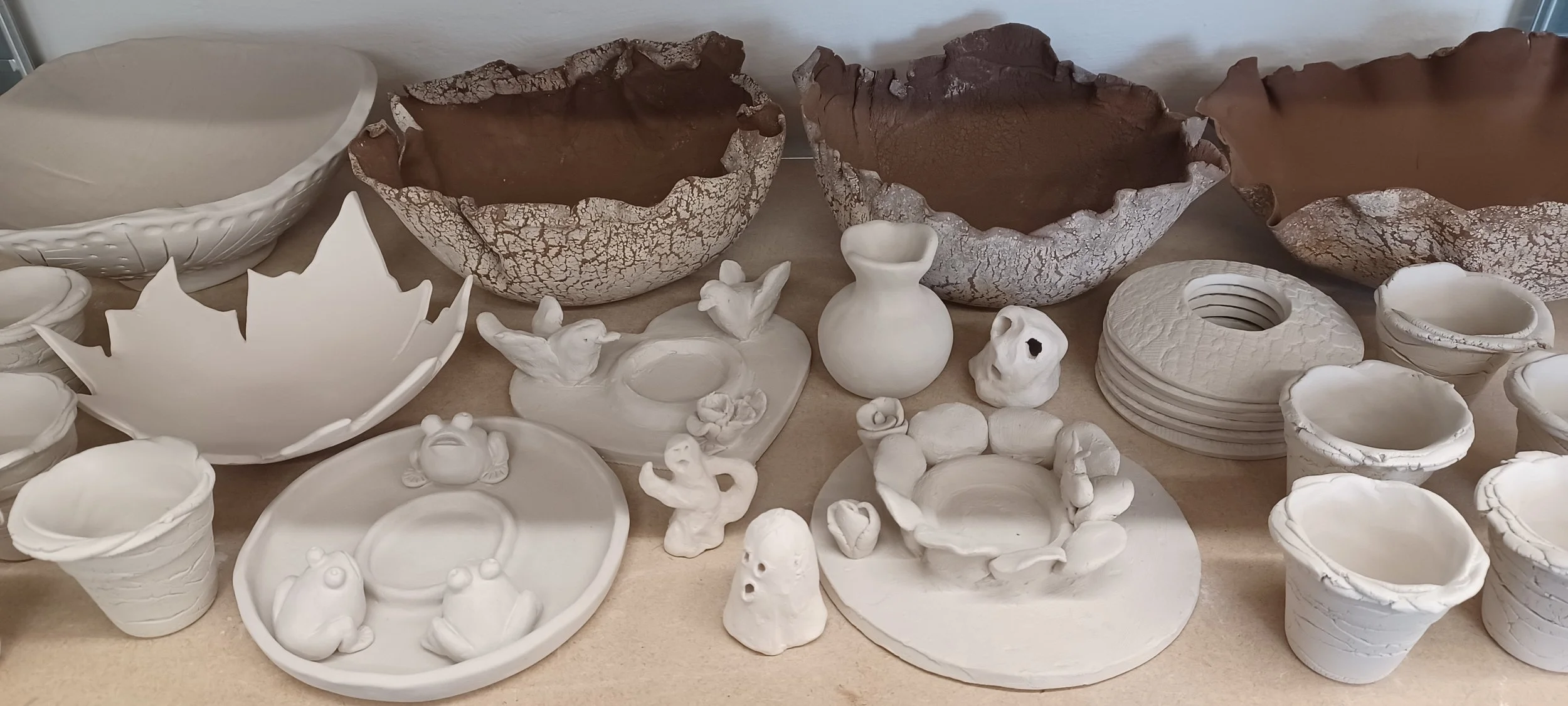Collection de créations en céramique mélangeant les techniques et les objets et invitant à la créativité : bols, bougeoirs, petites sculptures réalisées par des enfants, vase, coupelles et coquetiers.