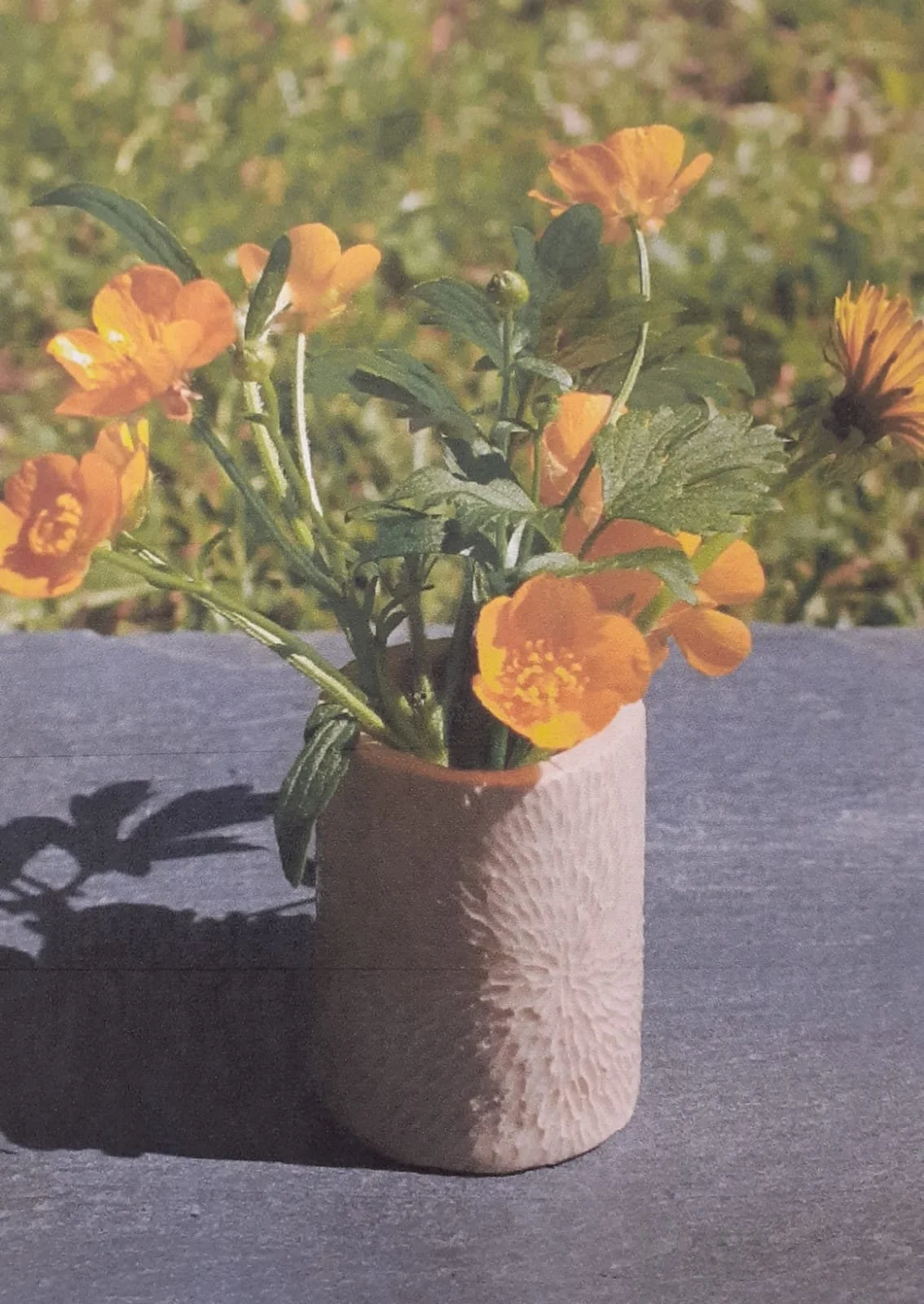 Poterie représentant un petit vase texturé de traits concentriques.