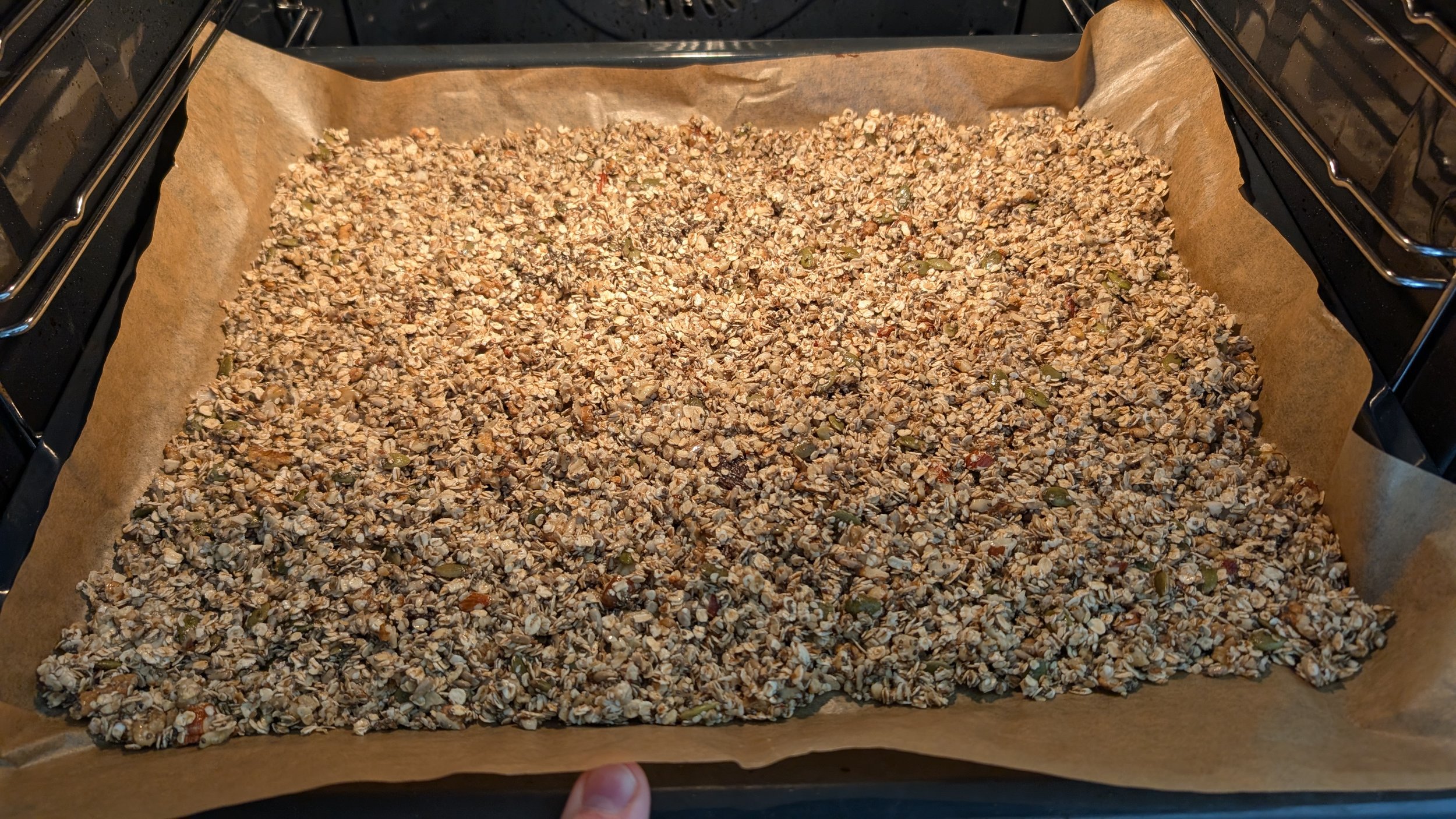 Granola étalé sur une plaque de four prêt à passer en cuisson