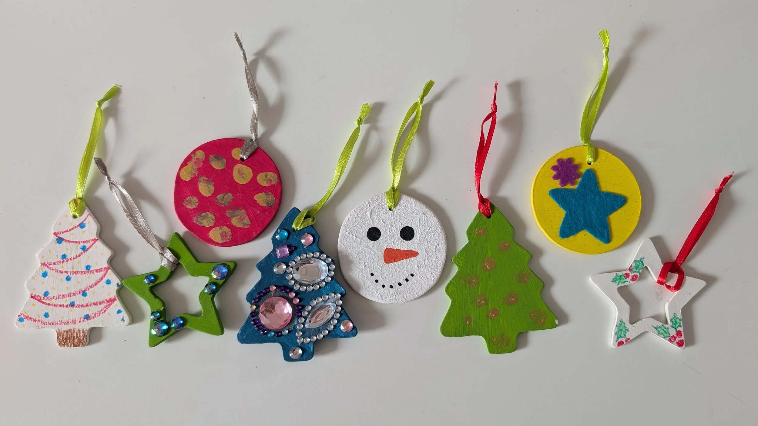 Suspensions de Noël réalisées en pâte à sel et décorées de peinture et de brillants autocollants