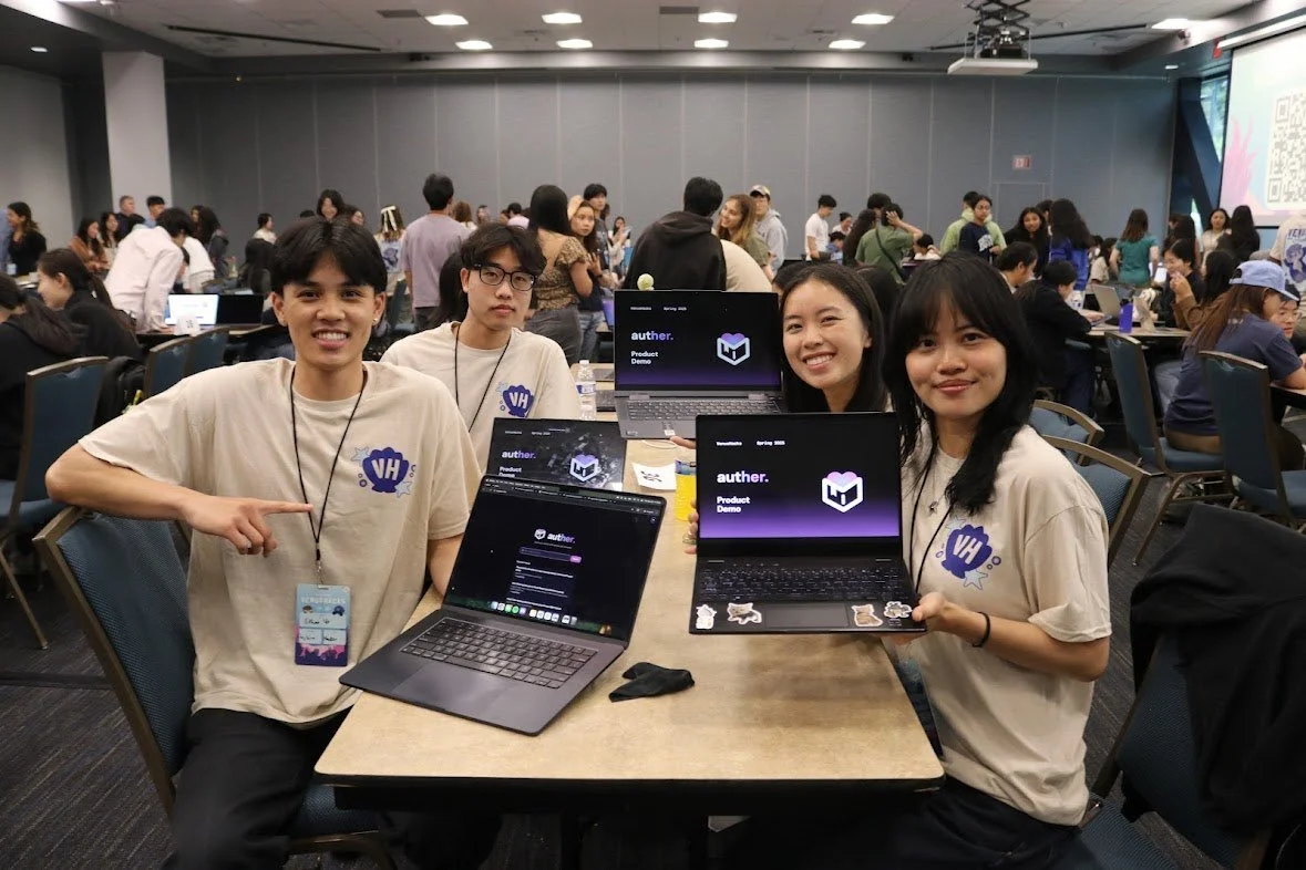 Four young people sitting at a table, proudly showcasing laptops displaying the brand 'authen' at a busy indoor tech event or conference.