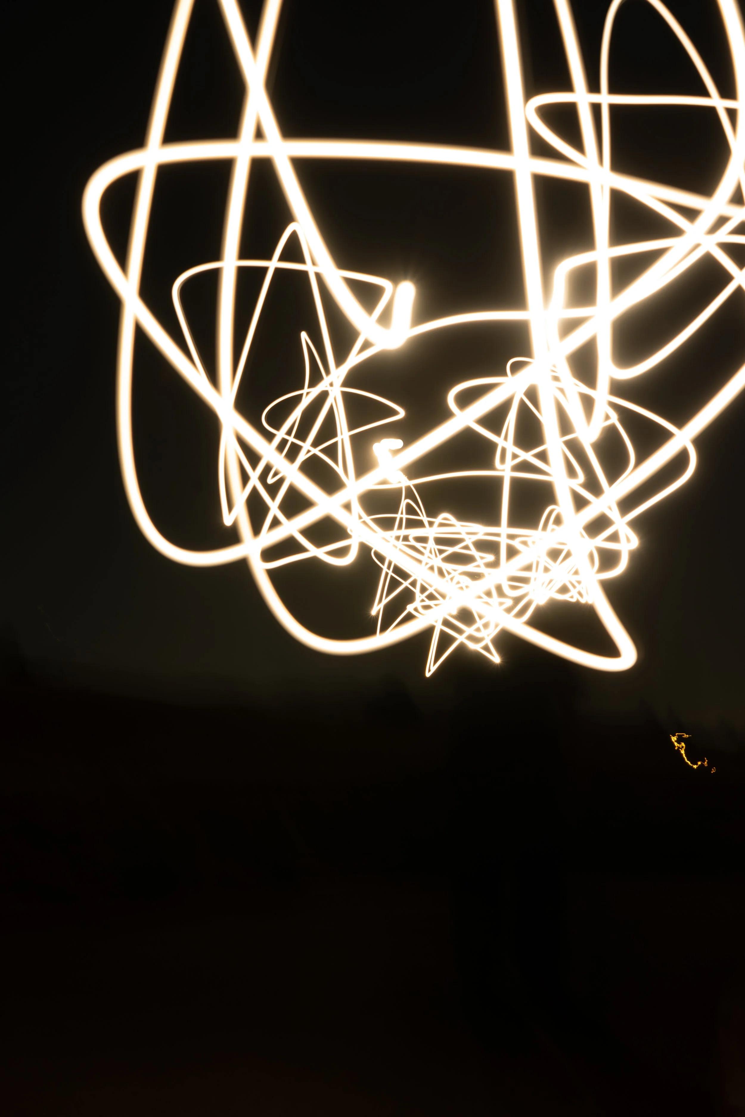 Light trails creating an abstract star pattern against a dark background.