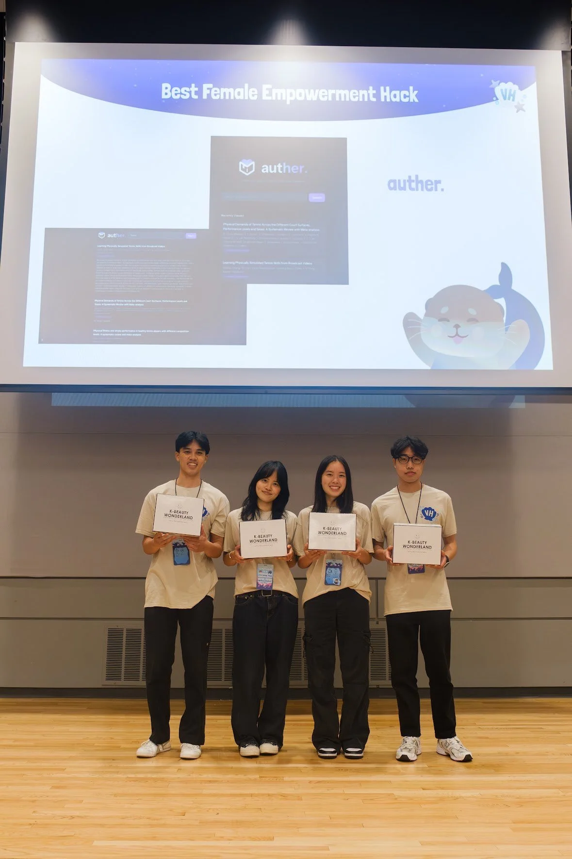 4 team members with matching clothing pose with their Hackathon prizes.