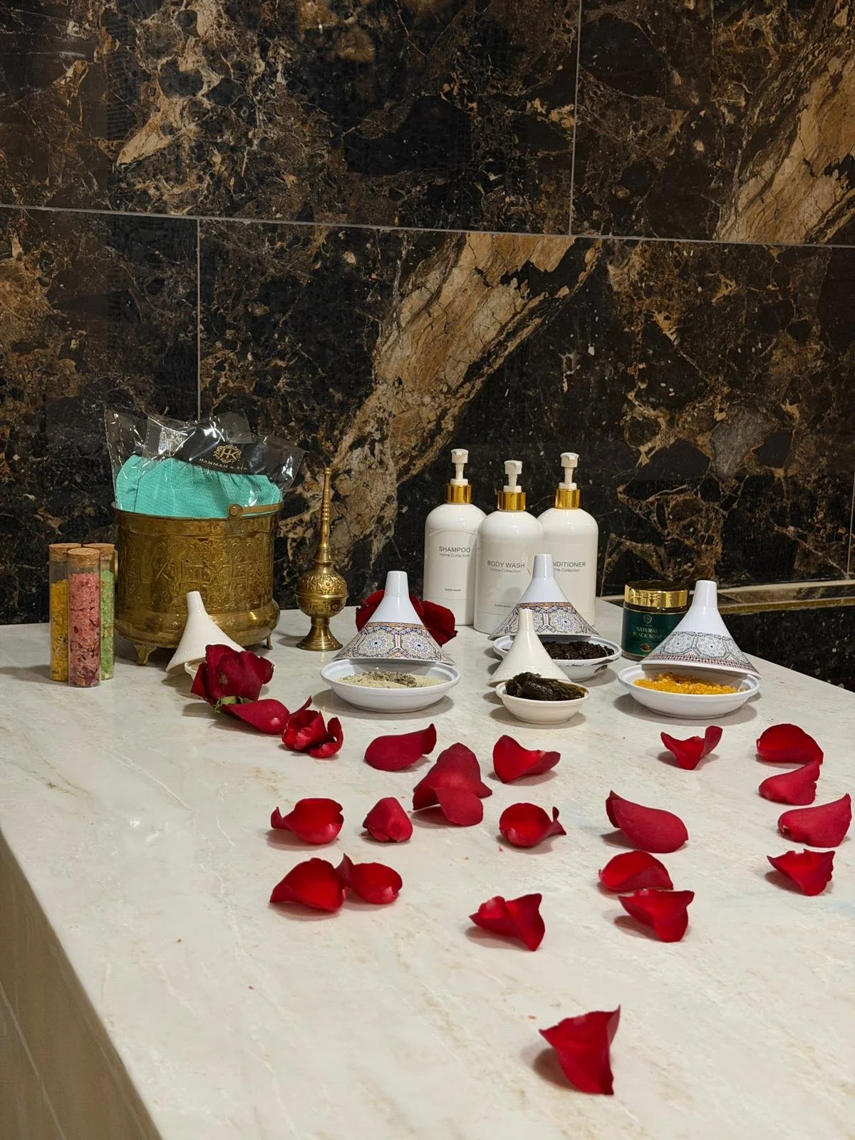 hammam bed at hk hammam spa with hammam products and red petals
