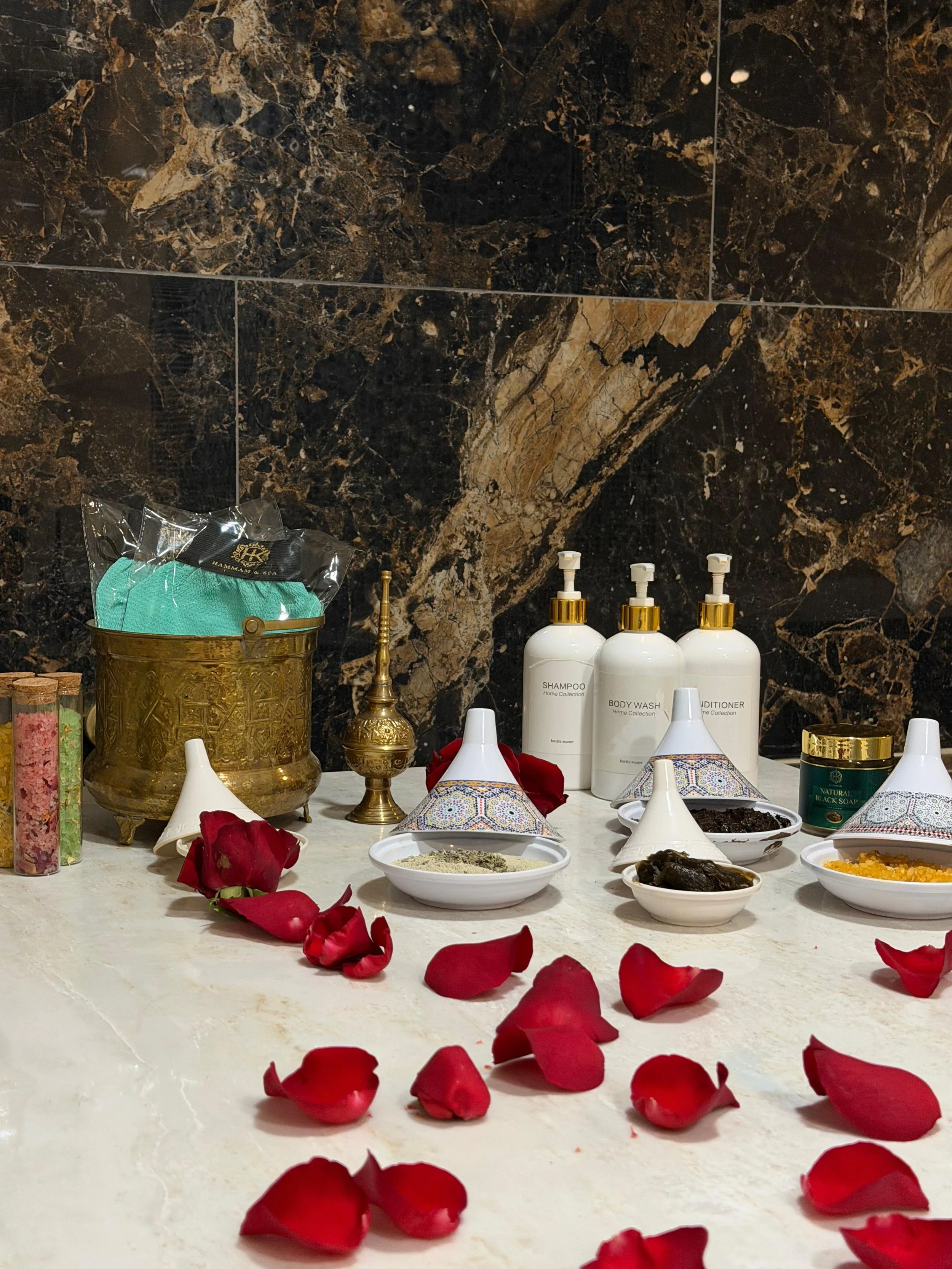 hammam bed set up with hammam products and red petals