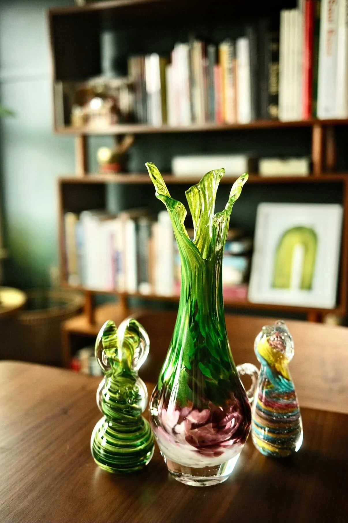 green and purple ramp vase next to two glass animals