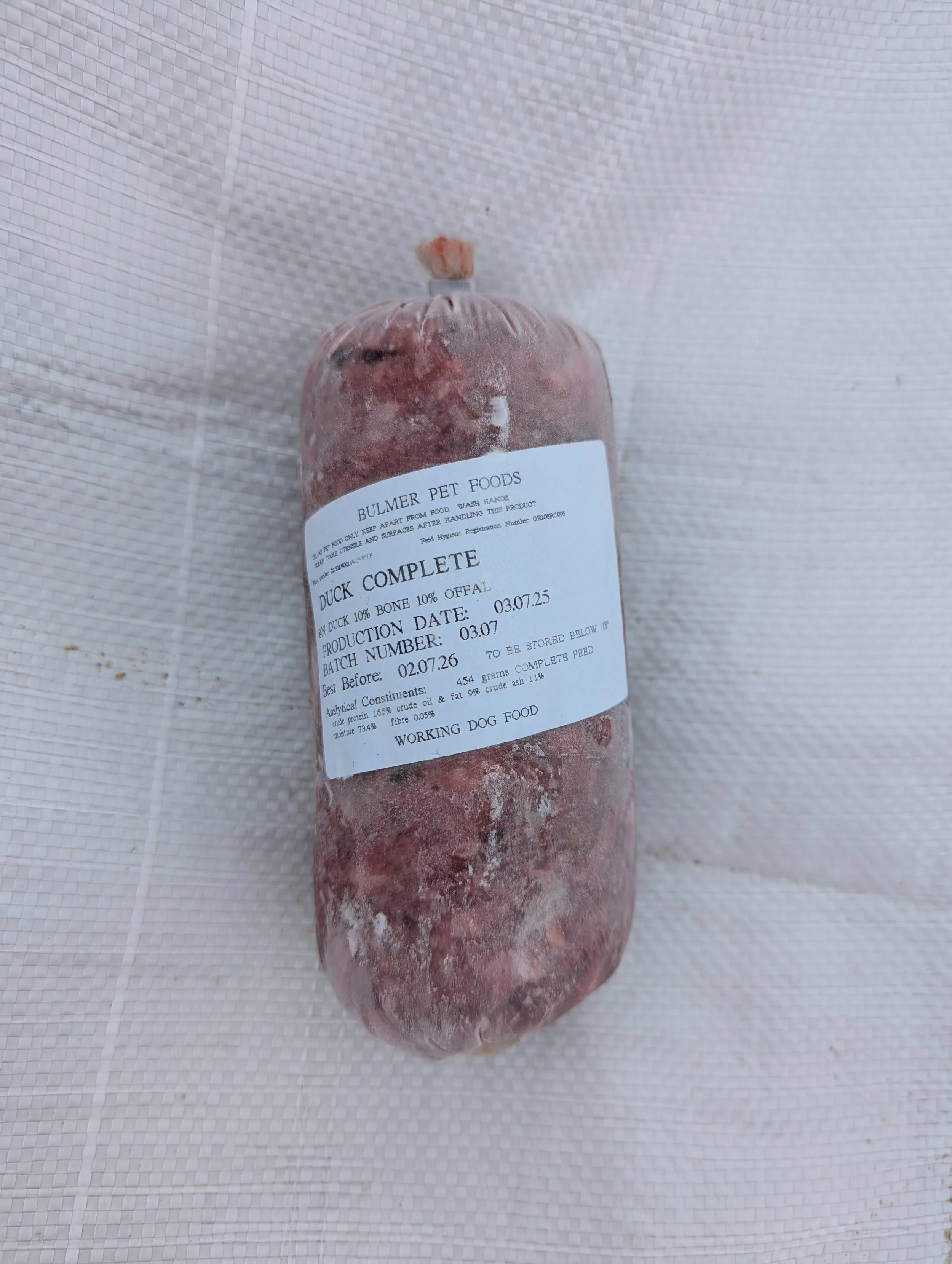 Frozen duck carcass with a white label indicating it is for working dog food, produced in March 2025.
