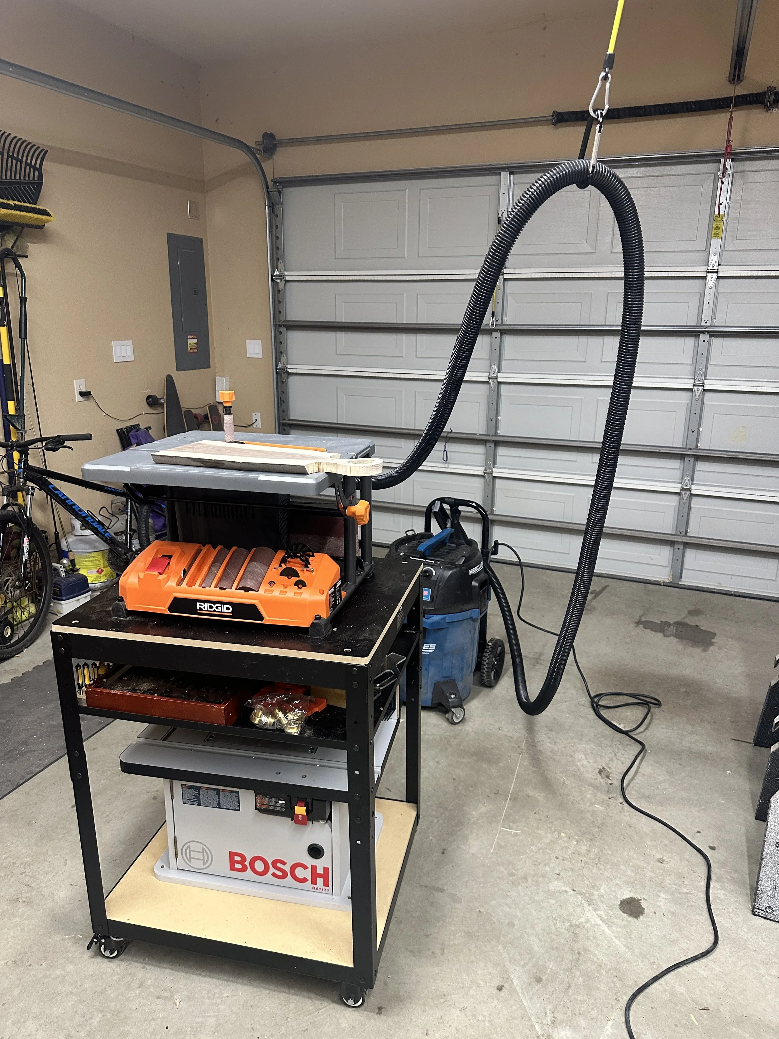 Ridgid Spindle Sander with woodworking station mounted on a portable stand, dust collection system, and storage shelves.