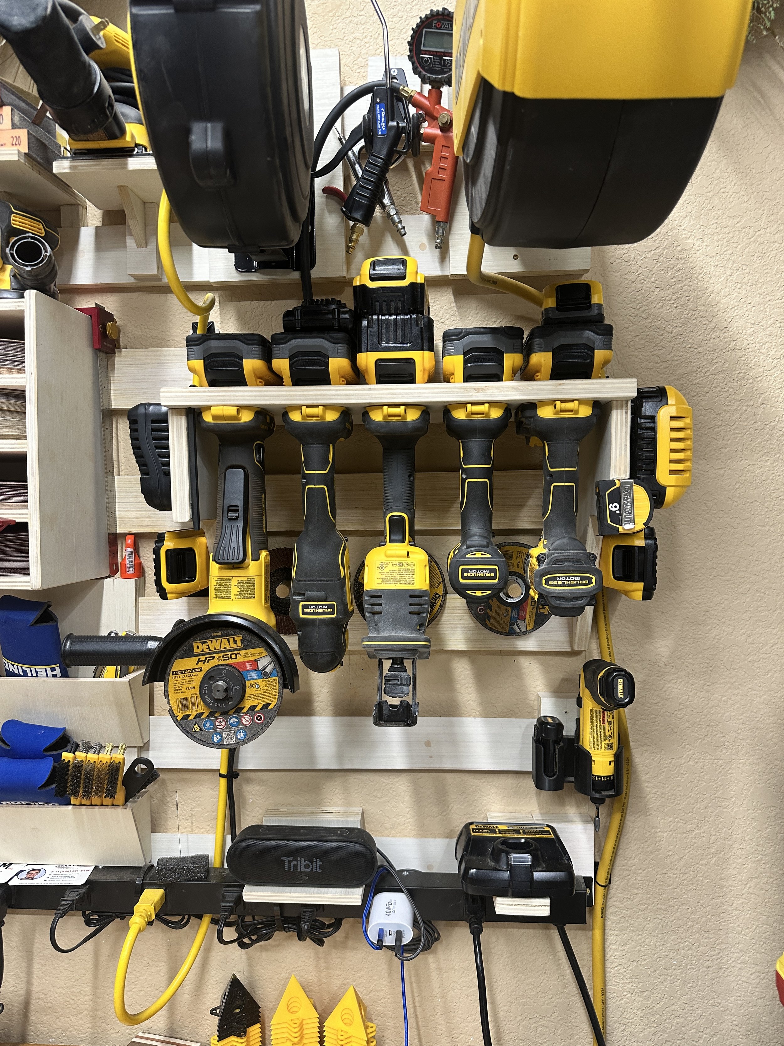 Dewalt 20V Grinder, Multi-Tool, Reciprocating Saw, Driver, and Drill, with battery storage above and chargers mounted on the side.