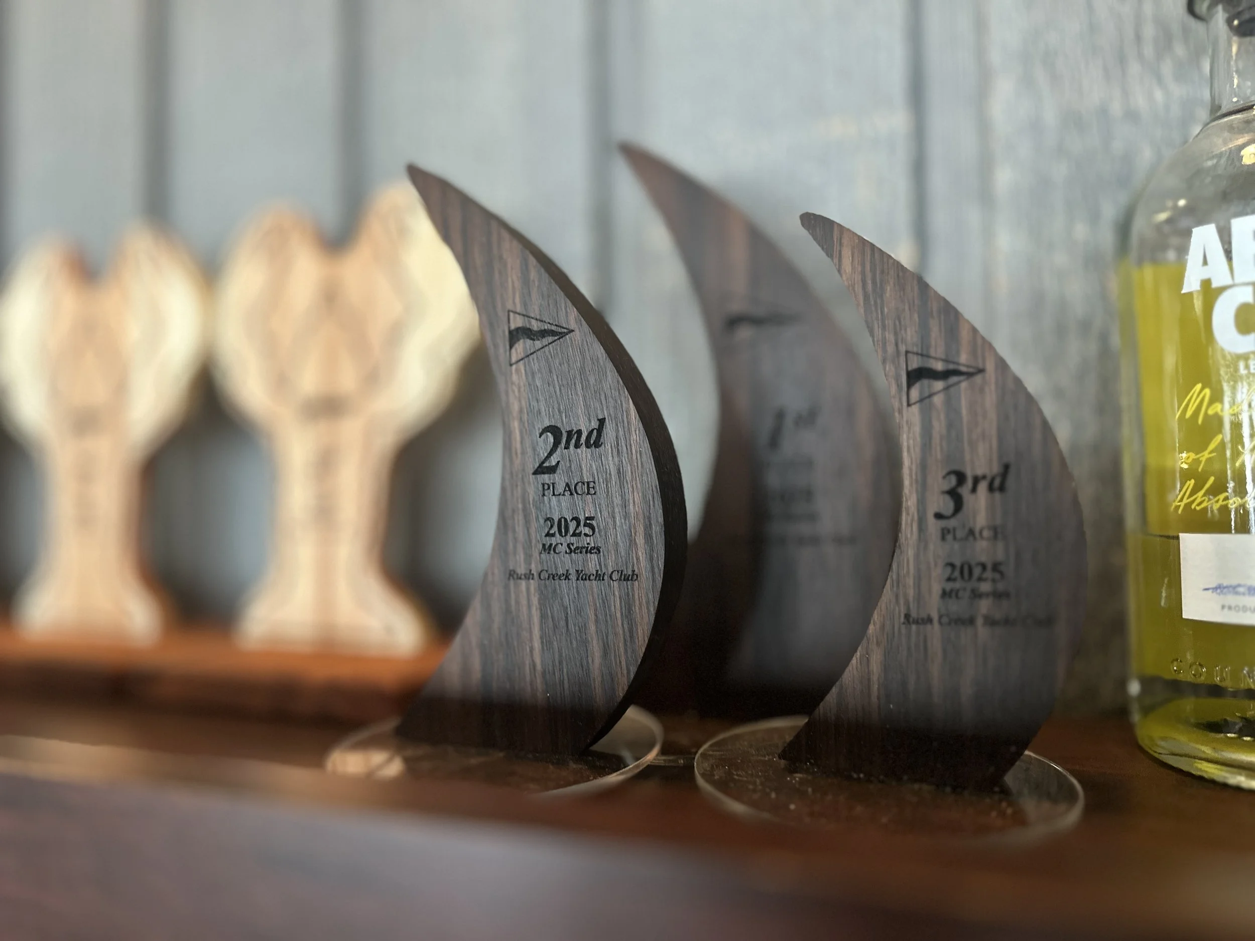 Custom sailing regatta series trophies crafted from Black Walnut with Acrylic bases.