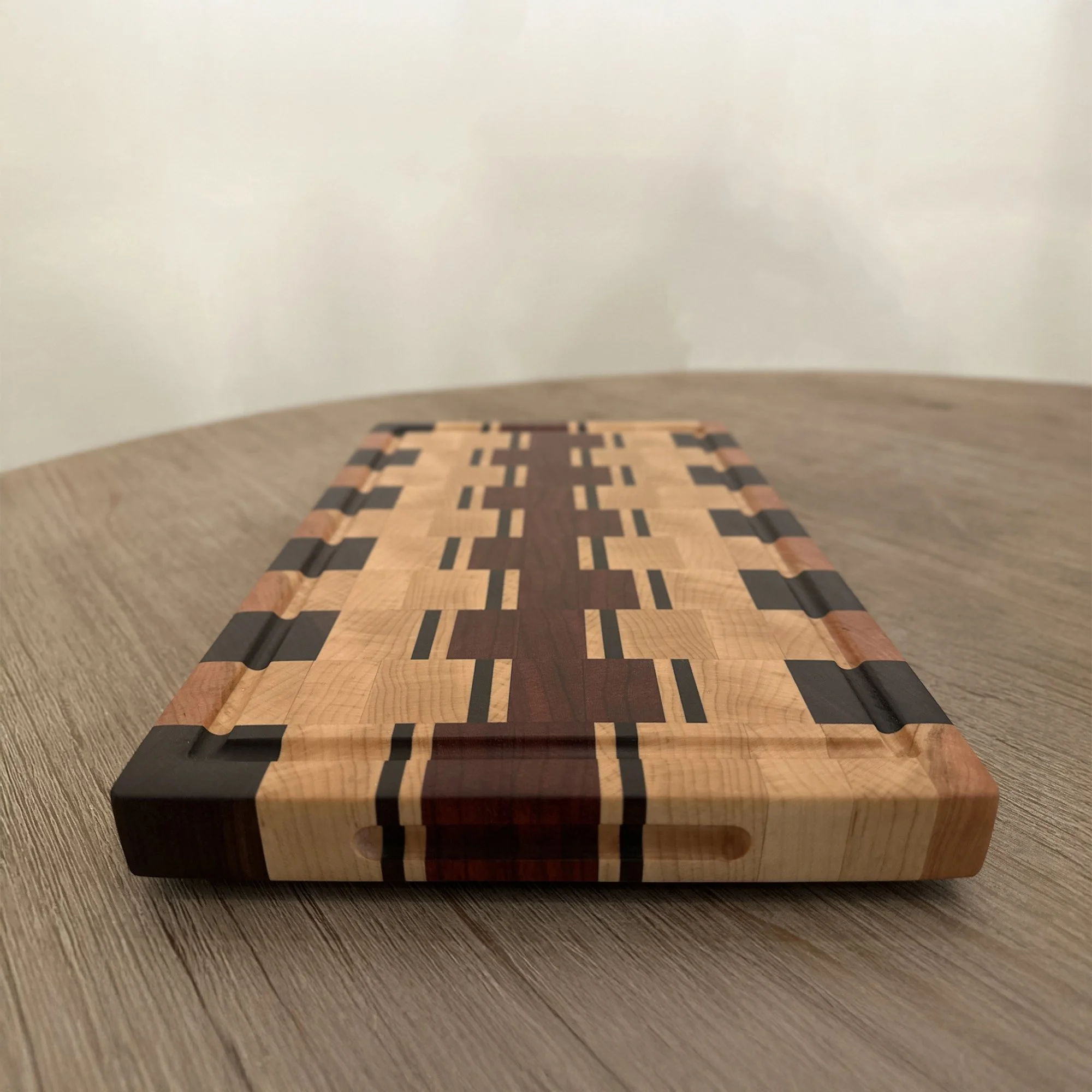 Beautiful End Grain Cutting Board designed from Walnut, Maple, Padauk, and Cherry hardwood, arranged in an eclectic pattern. 16 x 10