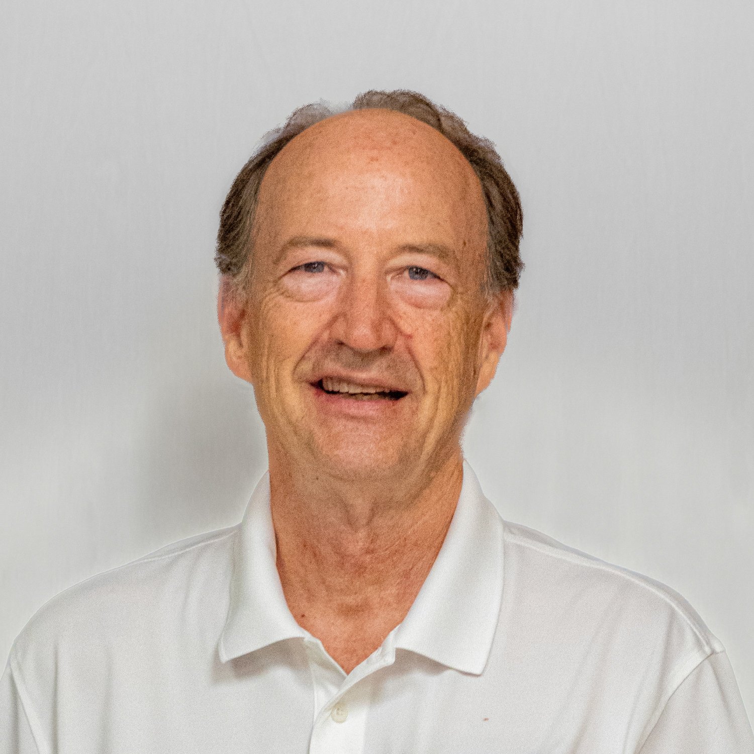 Portrait of a middle-aged man with a slight smile, wearing a white collared shirt, against a plain background.