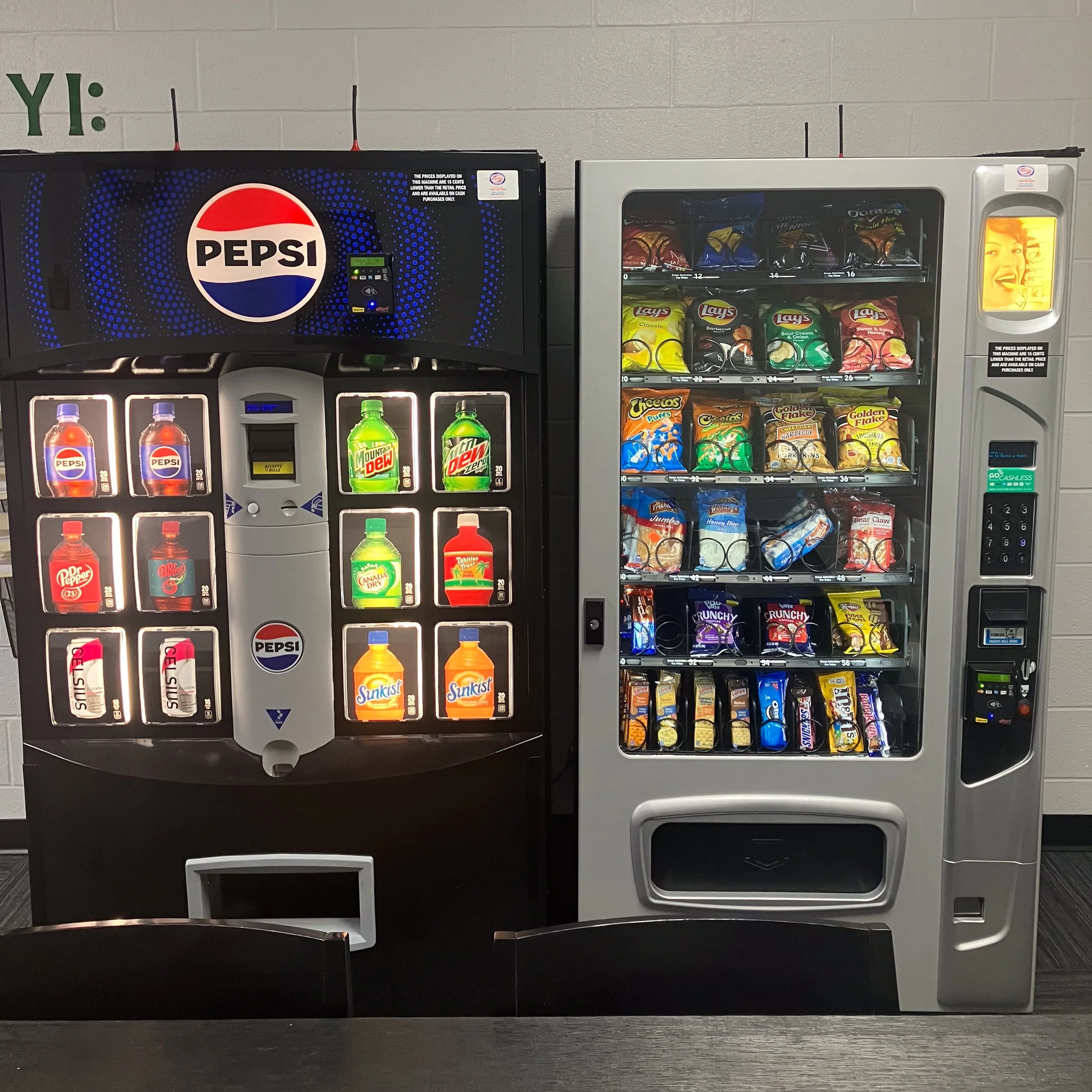 A vending machine for beverages on the left and a snack vending machine on the right.